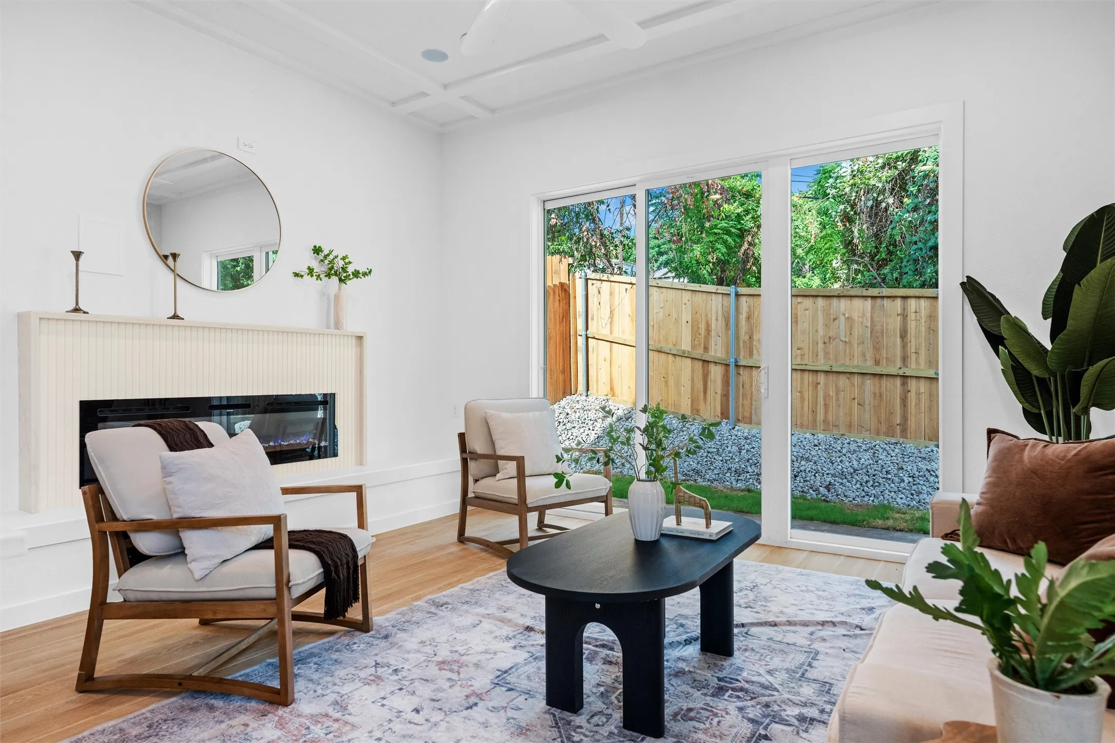 Living area featuring light wood-finish flooring and a contemporary fireplace with a decorative mantel
