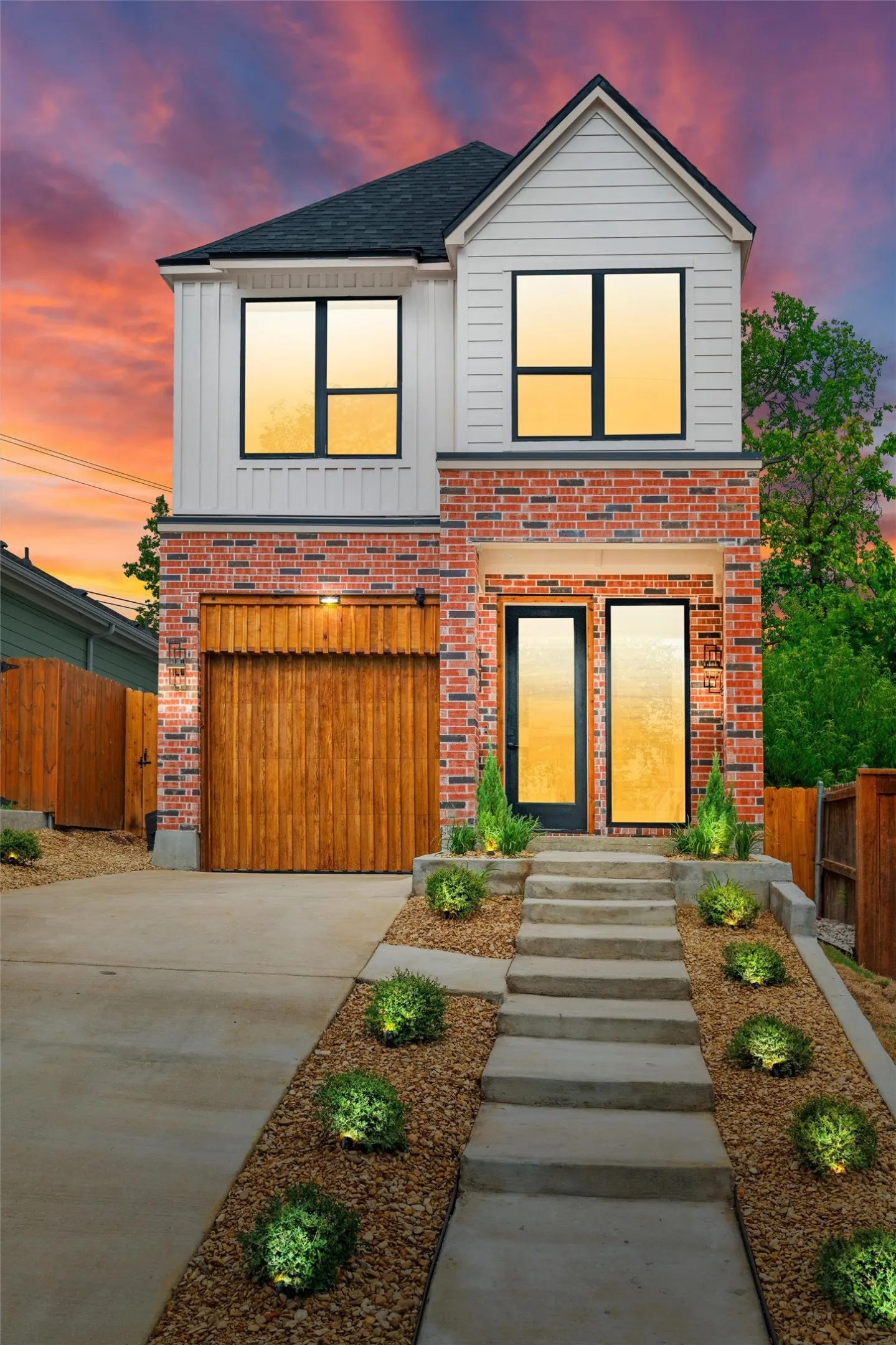Contemporary two-story exterior featuring a brick and vertical siding facade