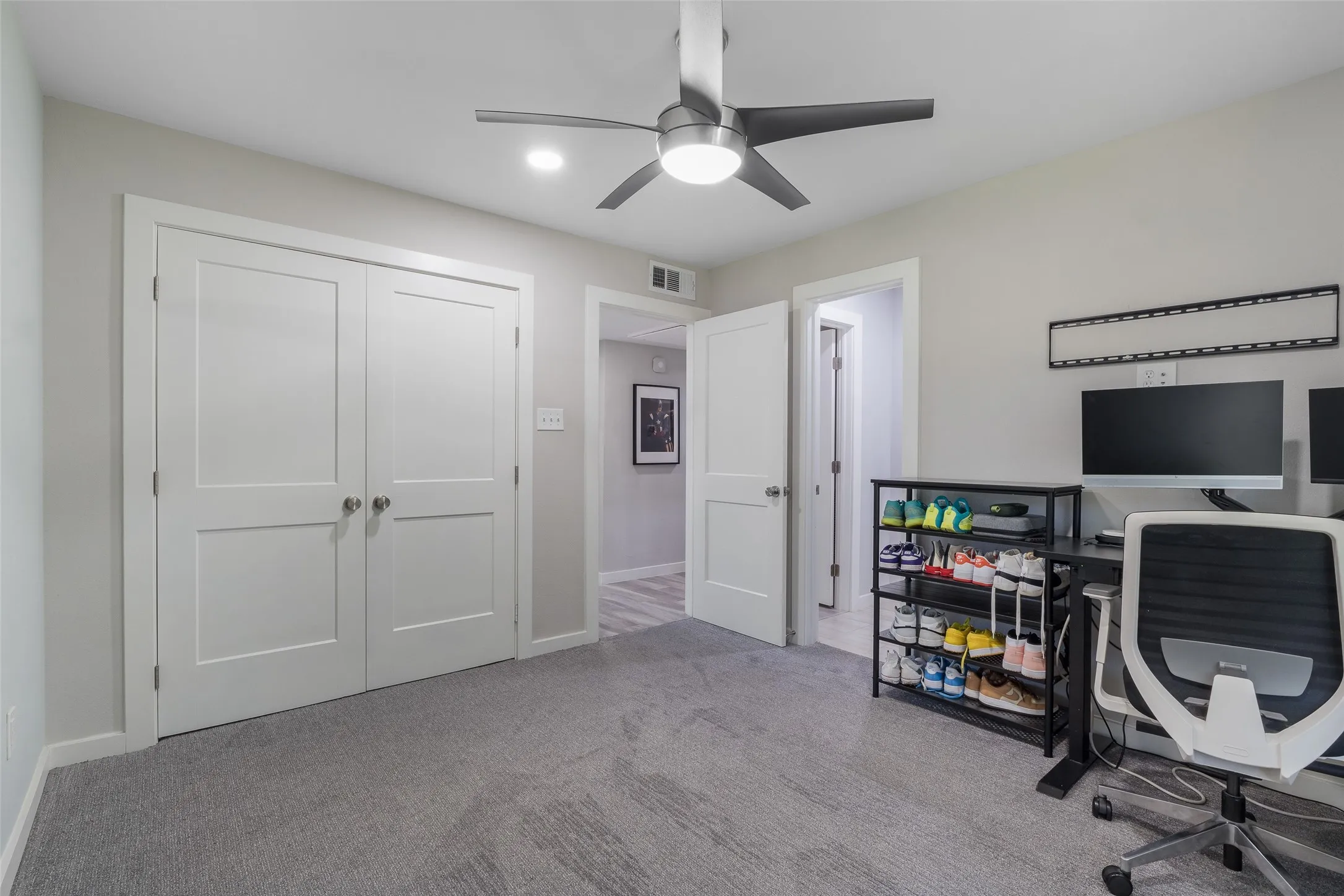 Light gray textured carpeting, modern ceiling fan with integrated lighting, recessed lighting, white panel doors
