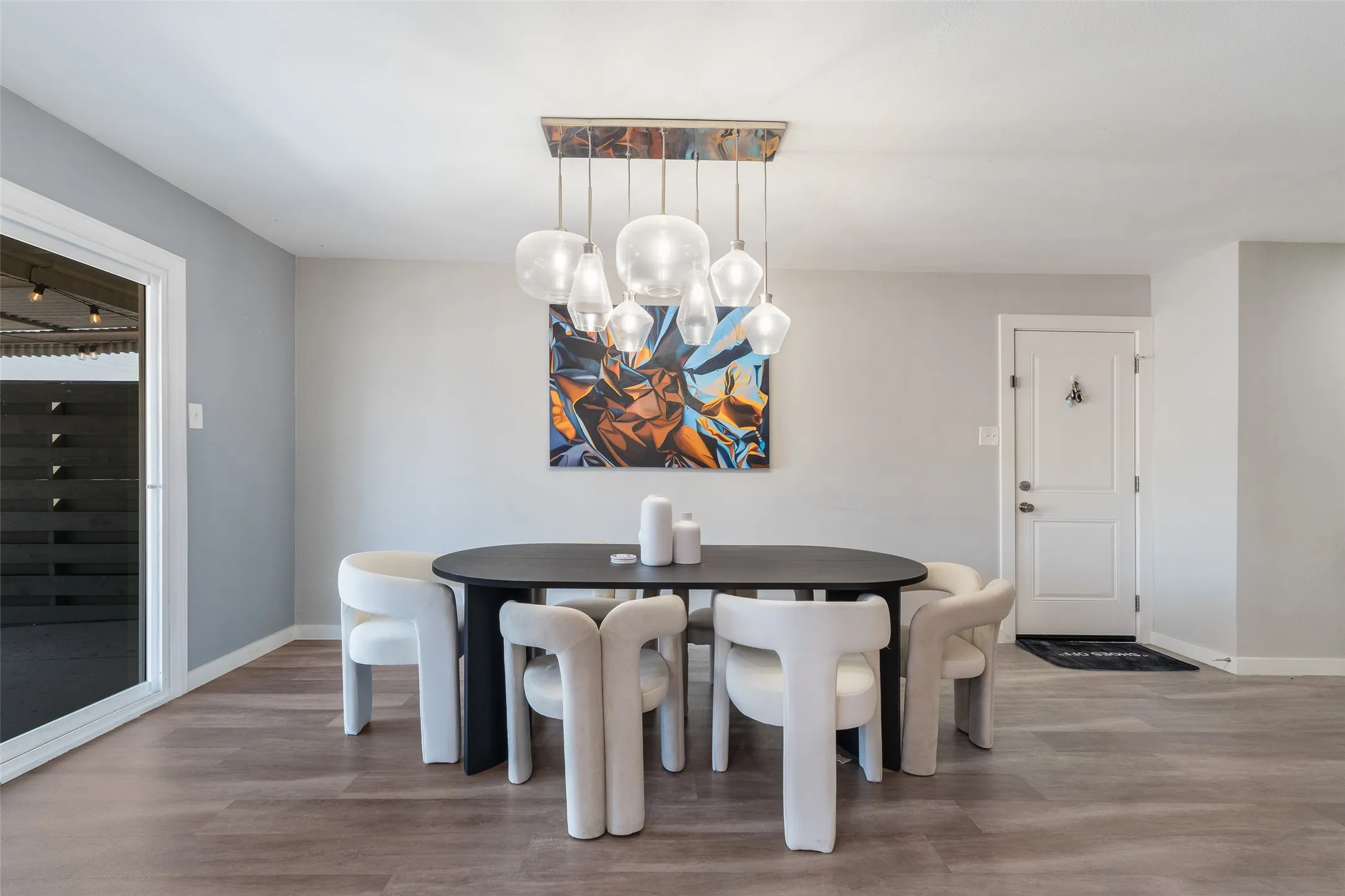Recessed lighting, light gray wall paint, wood-finish flooring, white trim, and a white paneled door