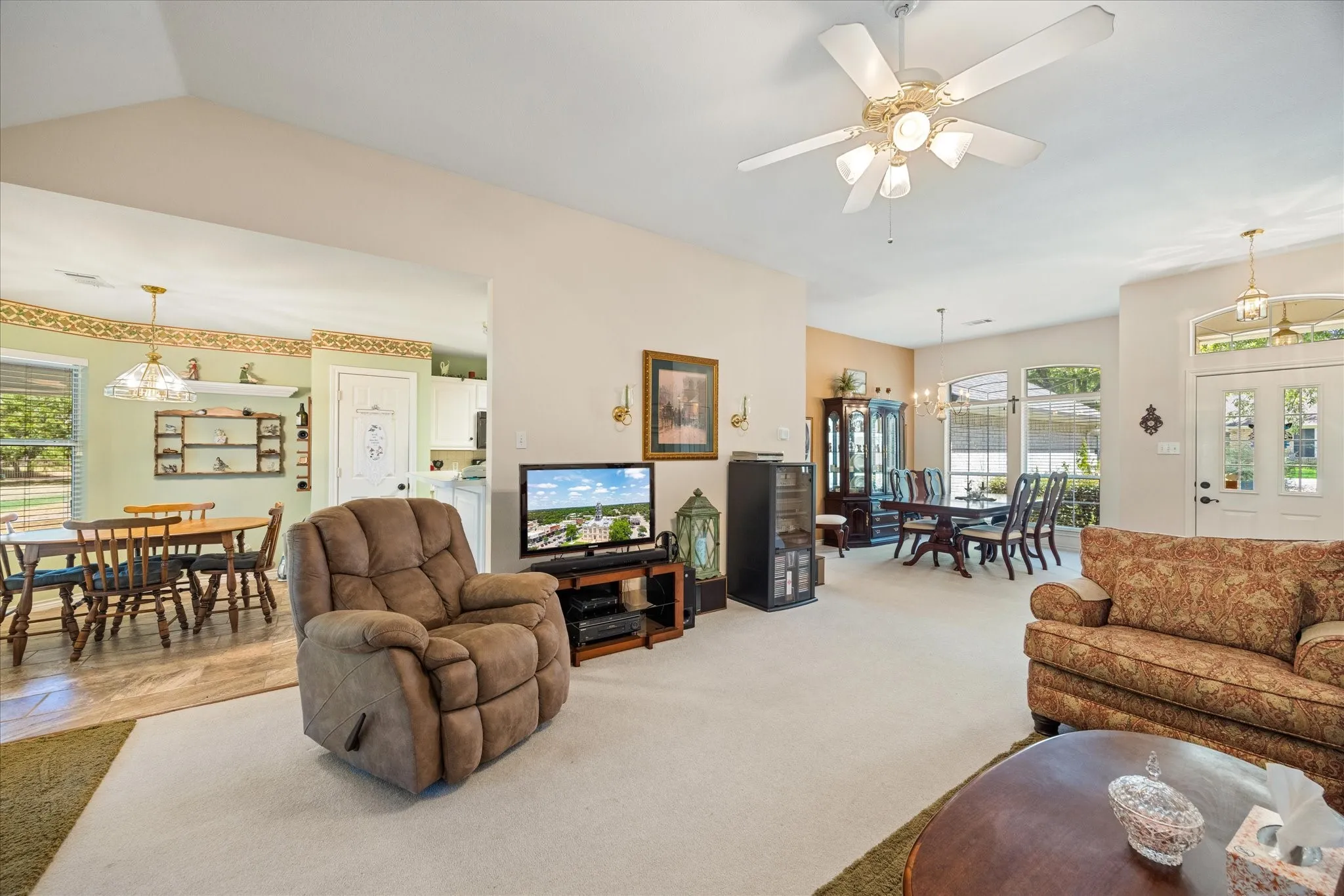 Recessed lighting, ceiling fan with integrated lighting, arched entry, panel entry door with upper glass inserts, multiple windows