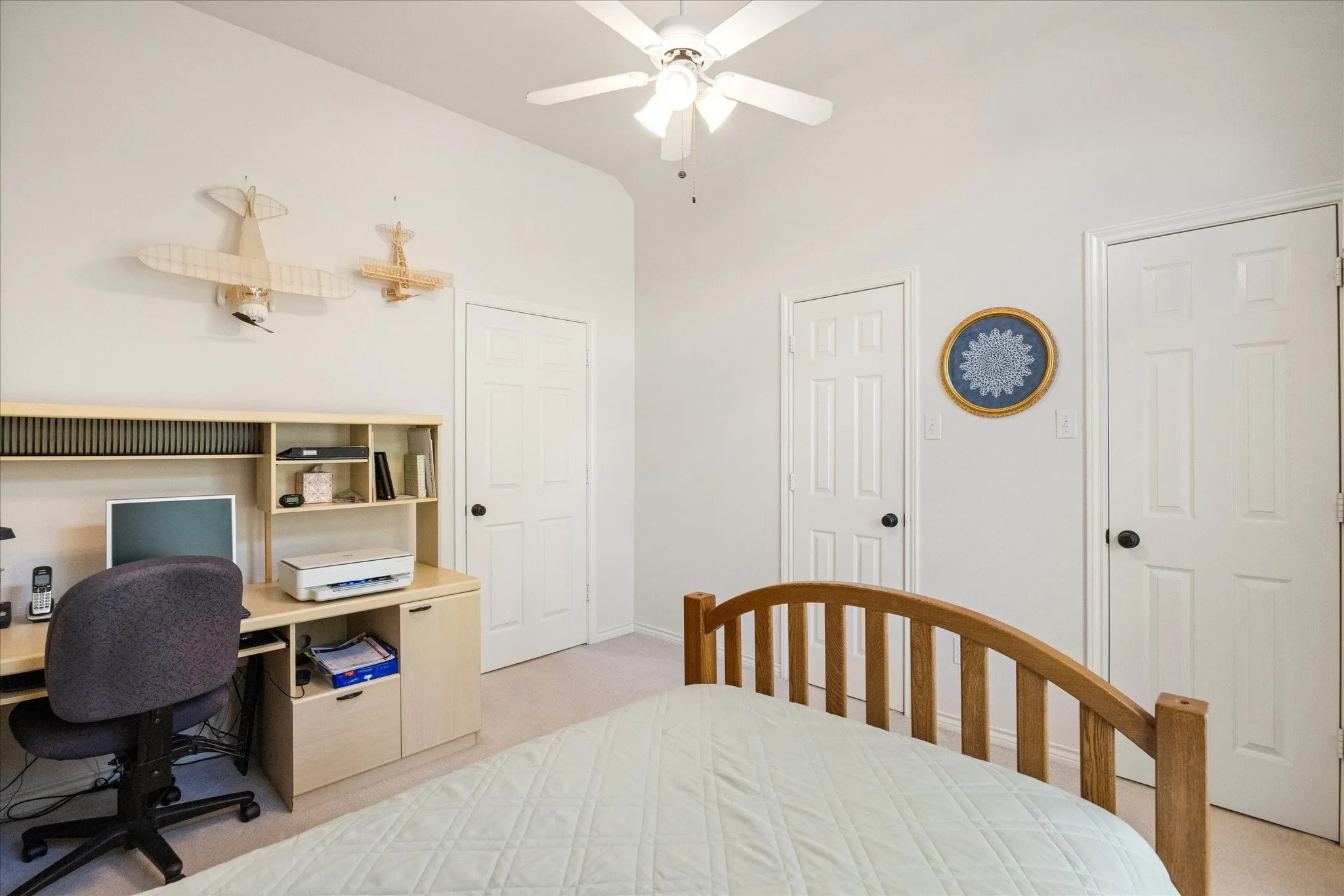 Vaulted ceiling with a ceiling fan, light-toned walls, and multiple paneled doors