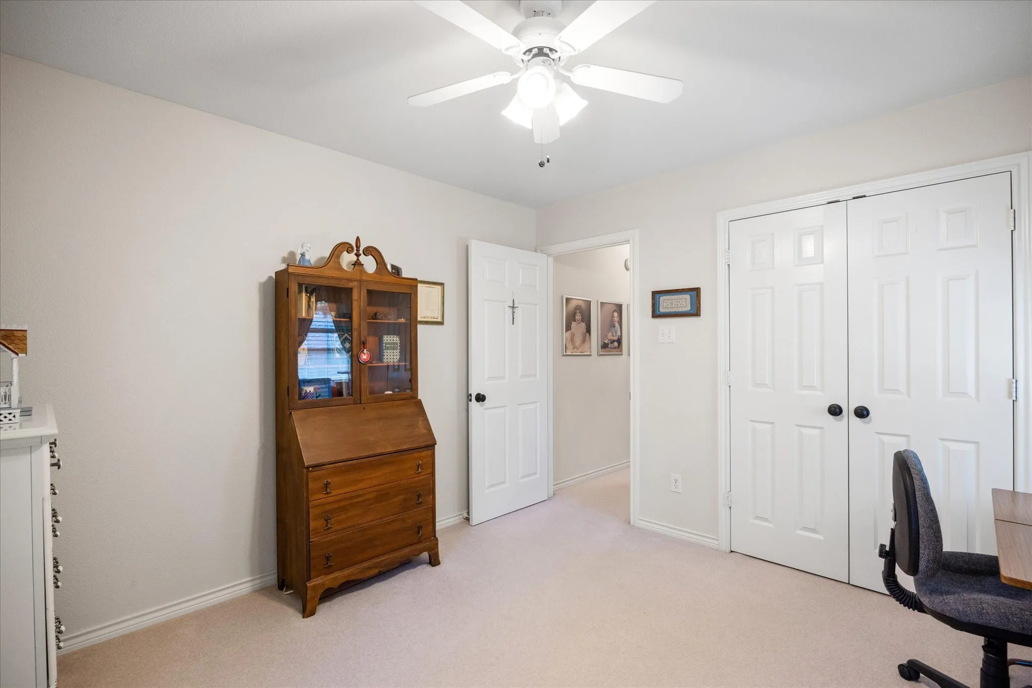 Neutral wall color, ceiling fan with integrated lighting, white paneled doors, and carpet flooring