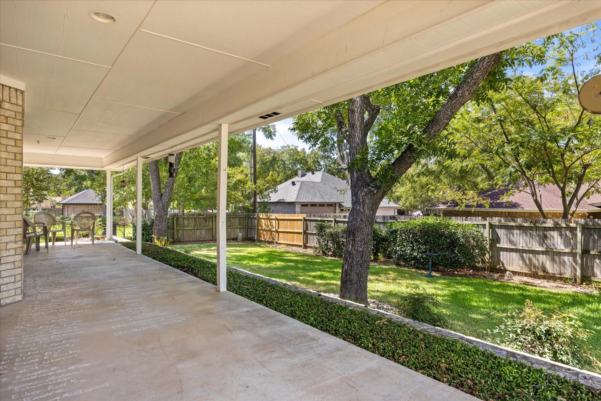Expansive covered patio with recessed lighting, brick pillar, and concrete flooring