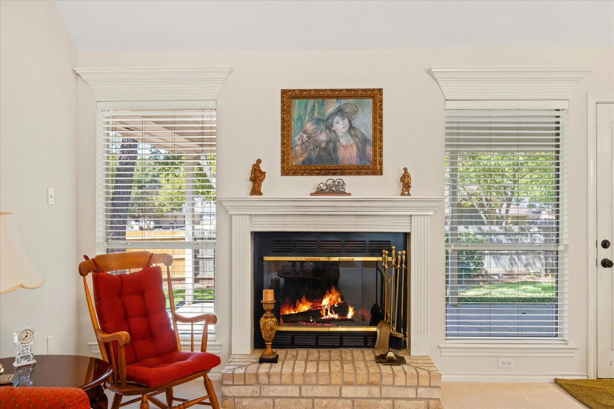 Central fireplace featuring a light brick hearth, white mantel, and integrated firebox