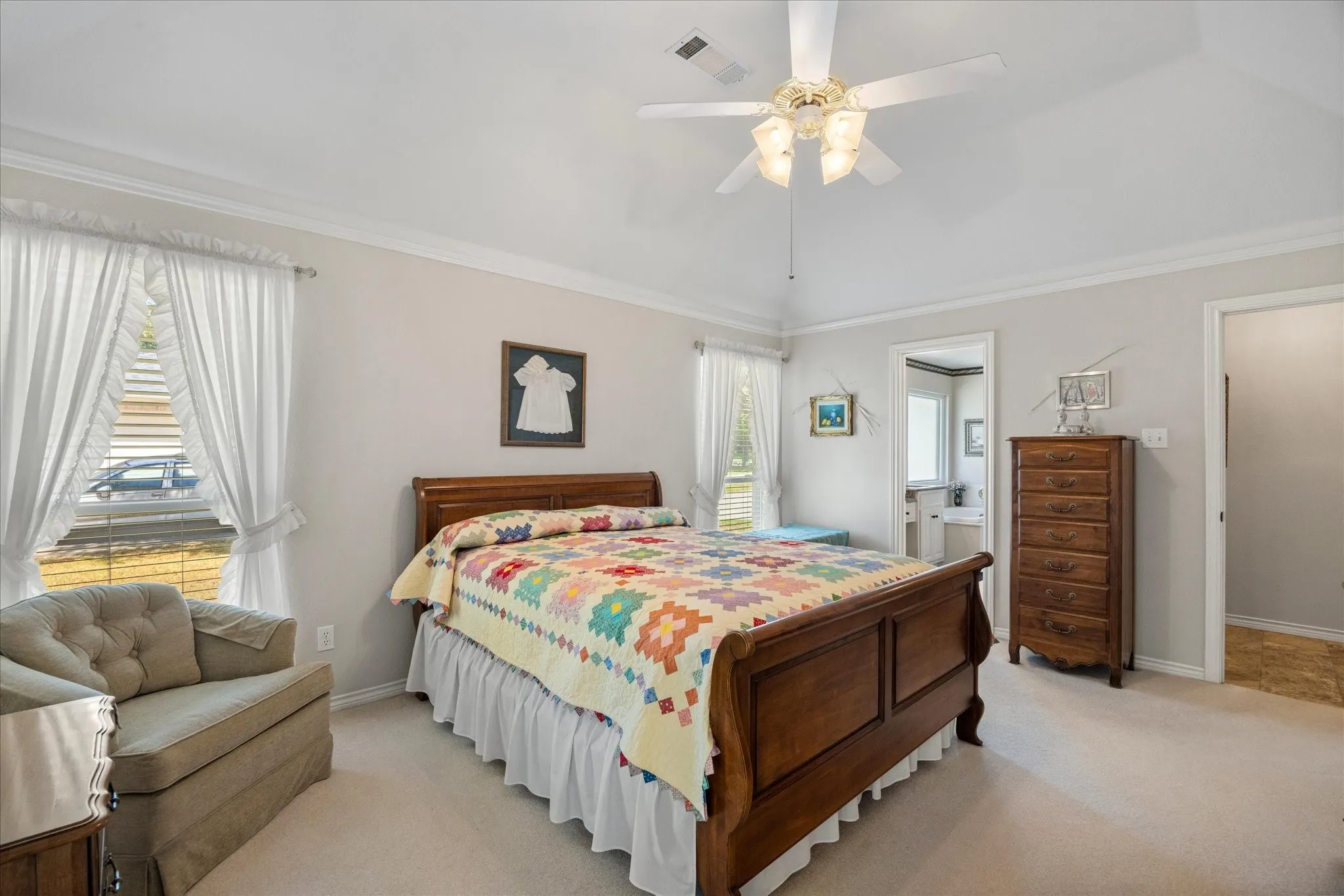 Vaulted ceiling with an attached ceiling fan, crown molding, and light-toned wall paint