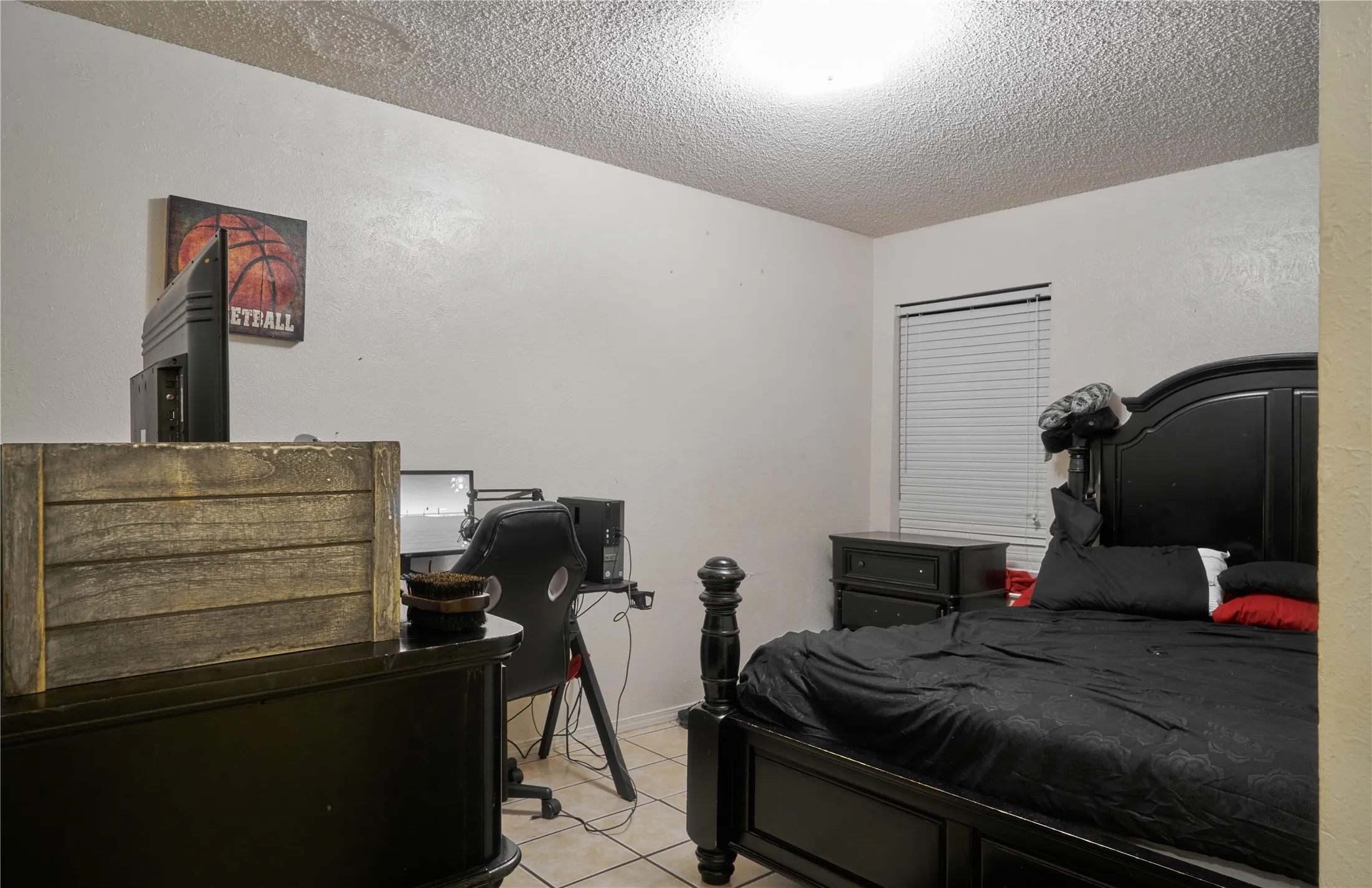 Bedroom featuring a textured ceiling and light tile floors