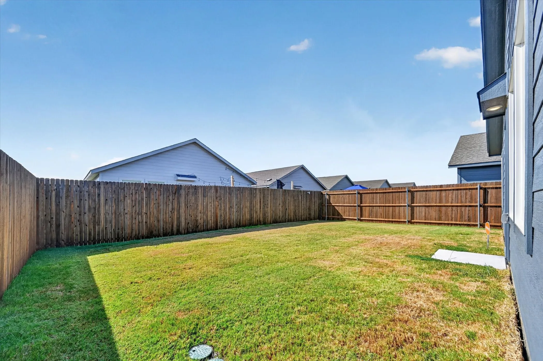 Expansive fenced backyard with a grassy lawn