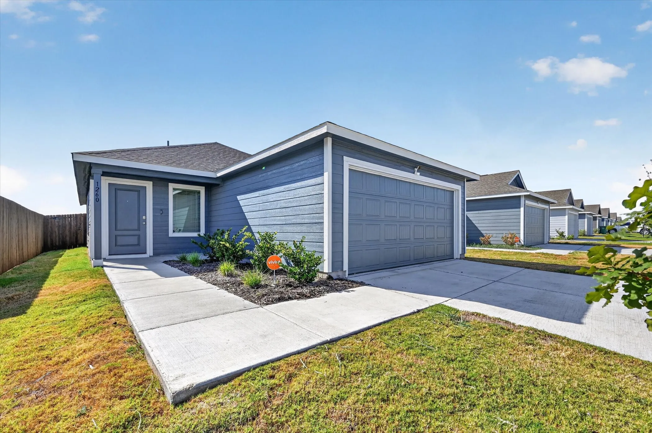 Single-story residence featuring horizontal siding, a dark asphalt shingle roof, and a concrete driveway