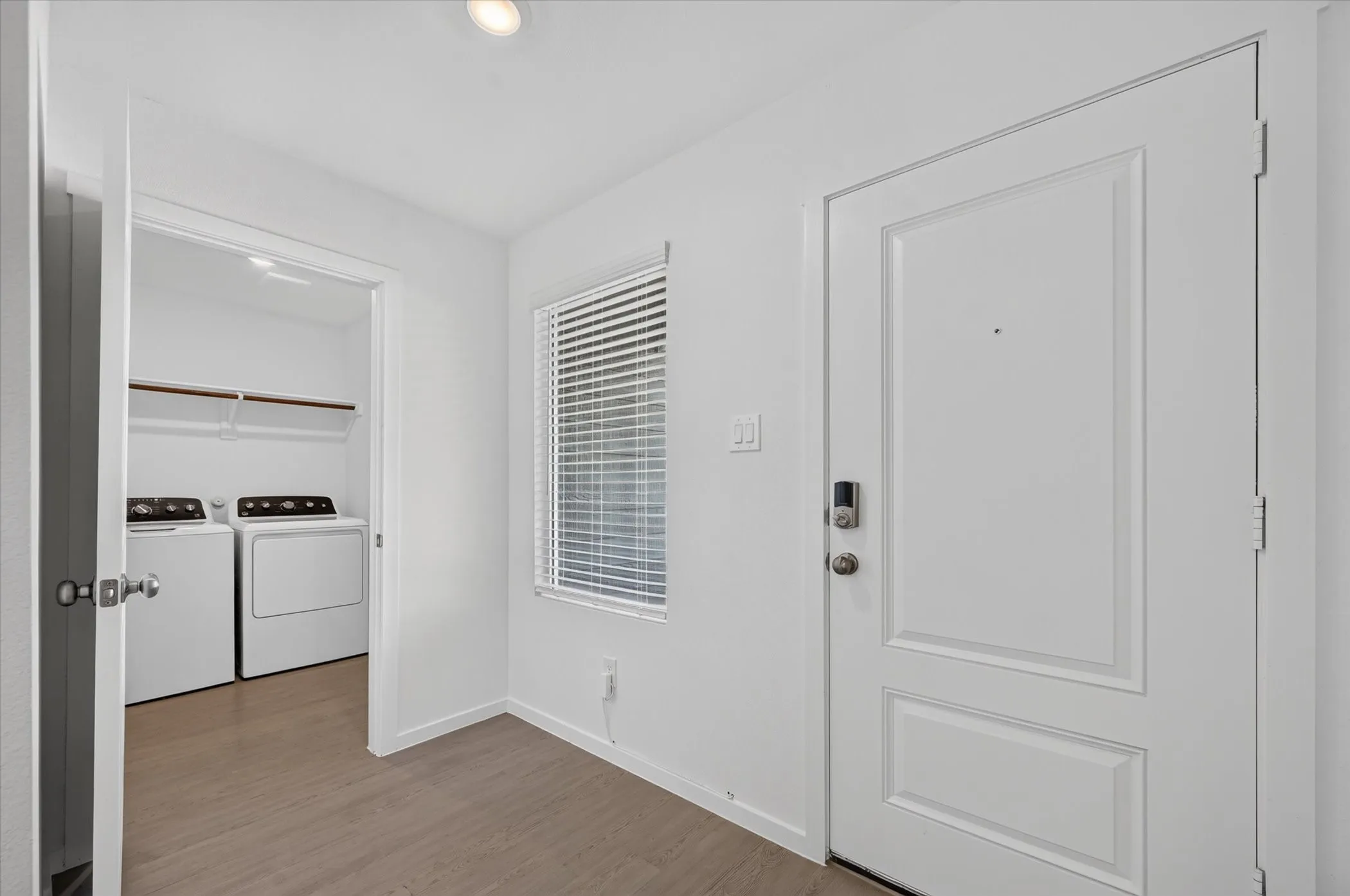 Entryway featuring a paneled door with digital lock, recessed lighting, and wood-finish flooring