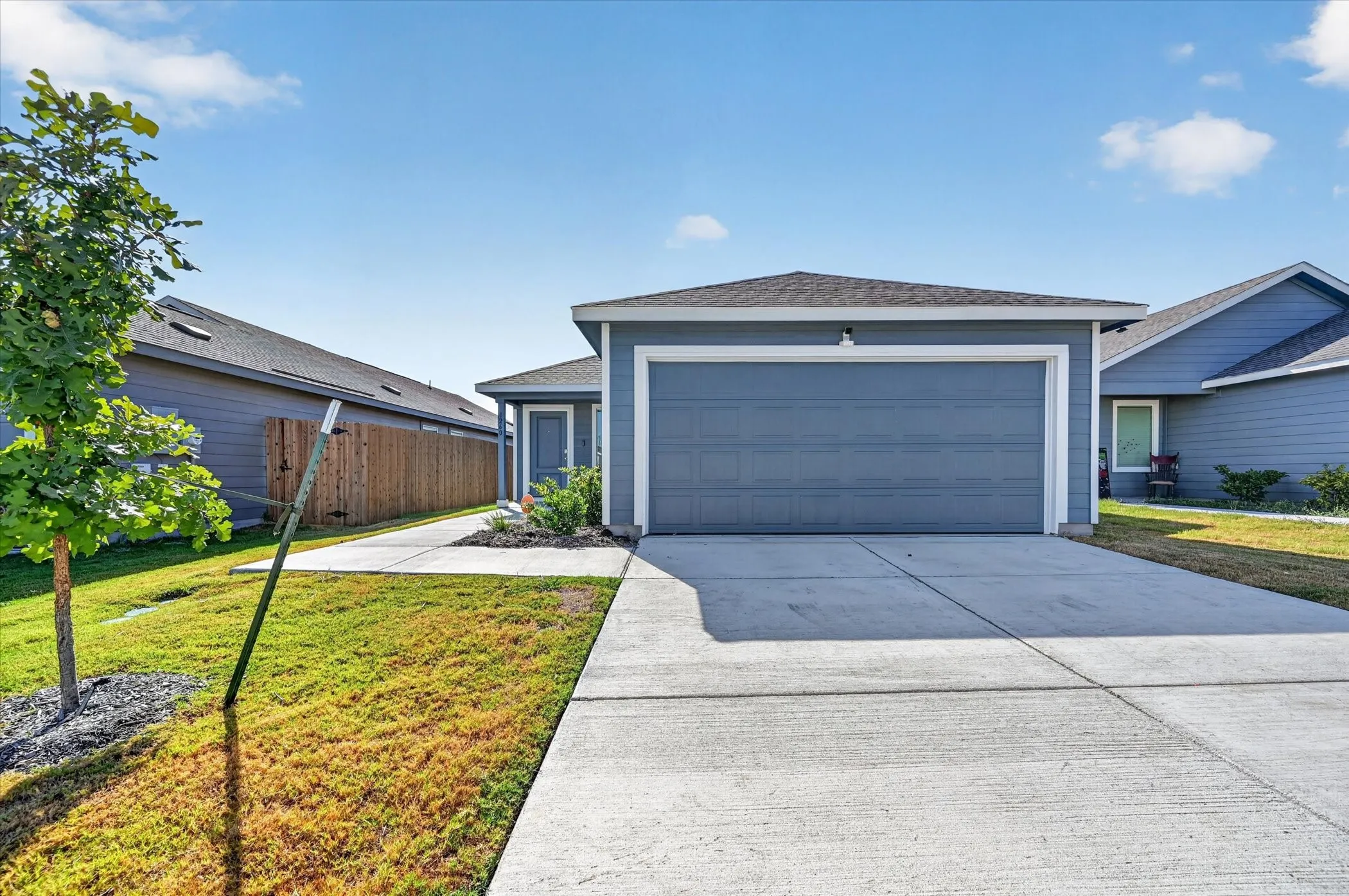 Single-story residence featuring a blue siding exterior, attached two-car garage, and concrete driveway