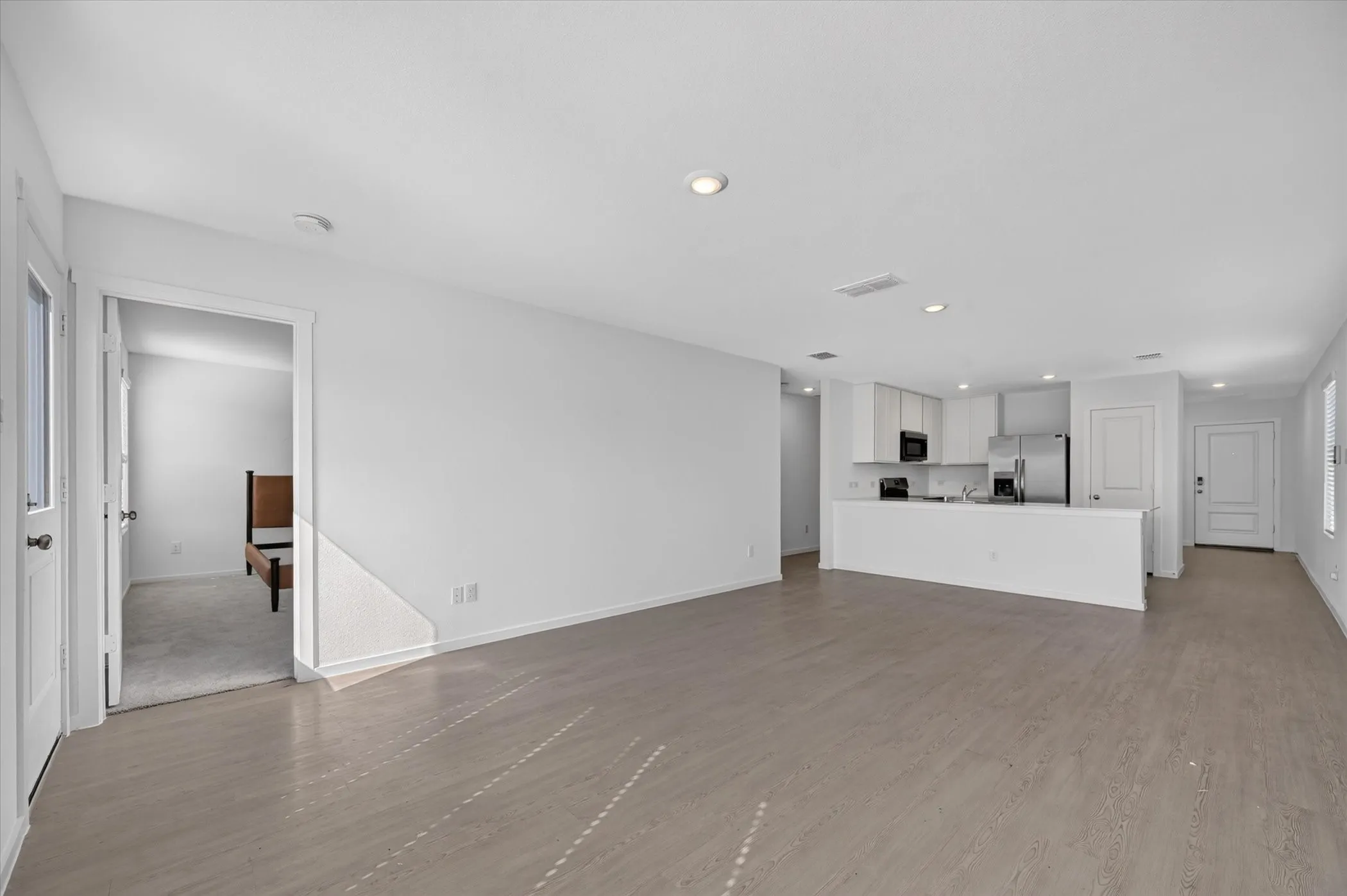 Open-concept living space featuring wood-finish flooring and recessed lighting