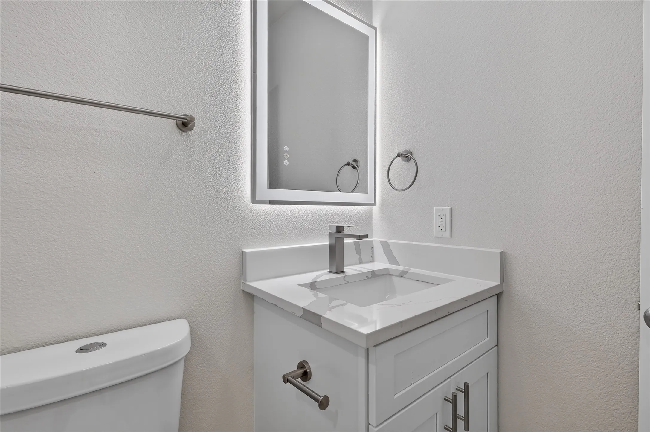 Vanity with integrated sink, modern faucet, and white countertop