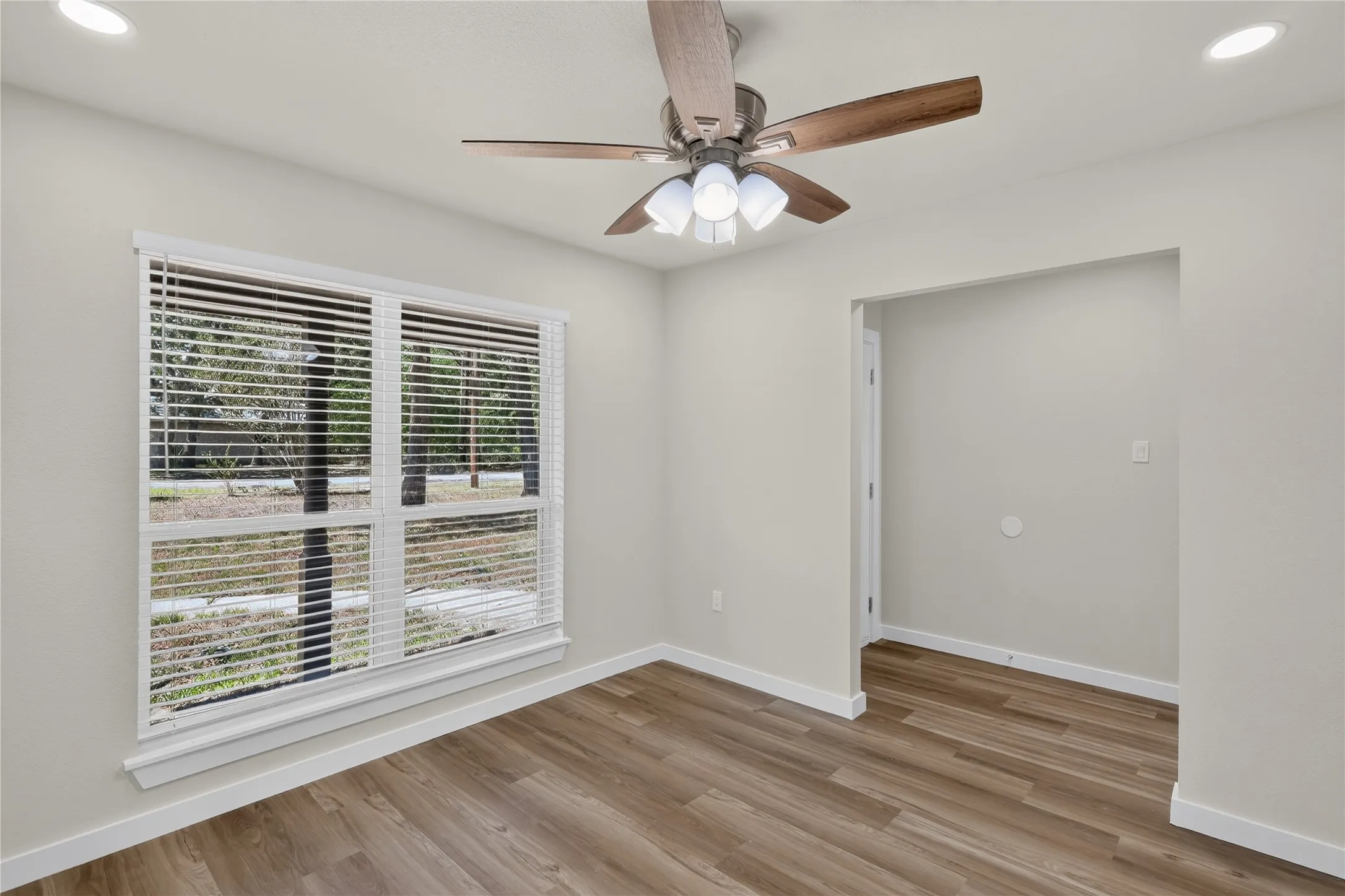 Wood-finish flooring, recessed lighting, and a ceiling fan with integrated light fixture