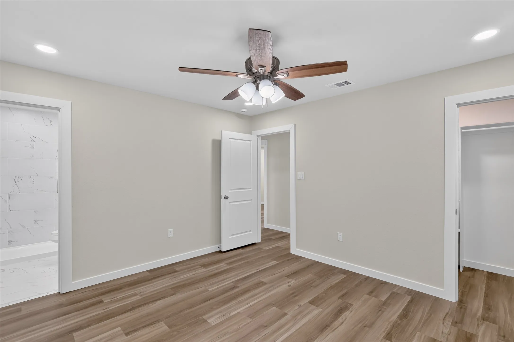 Recessed lighting, wood-finish flooring, ceiling fan with integrated lighting, and white interior doors
