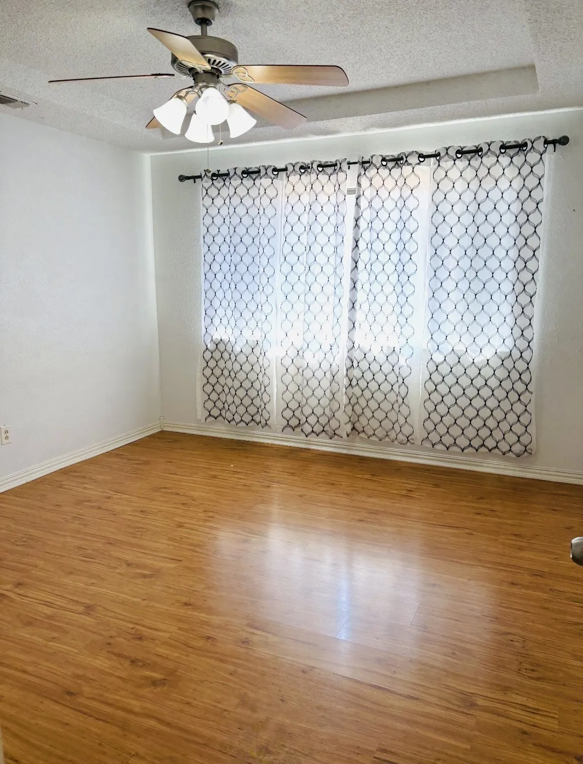 Wood-finish flooring throughout, complemented by a ceiling fan with integrated lighting