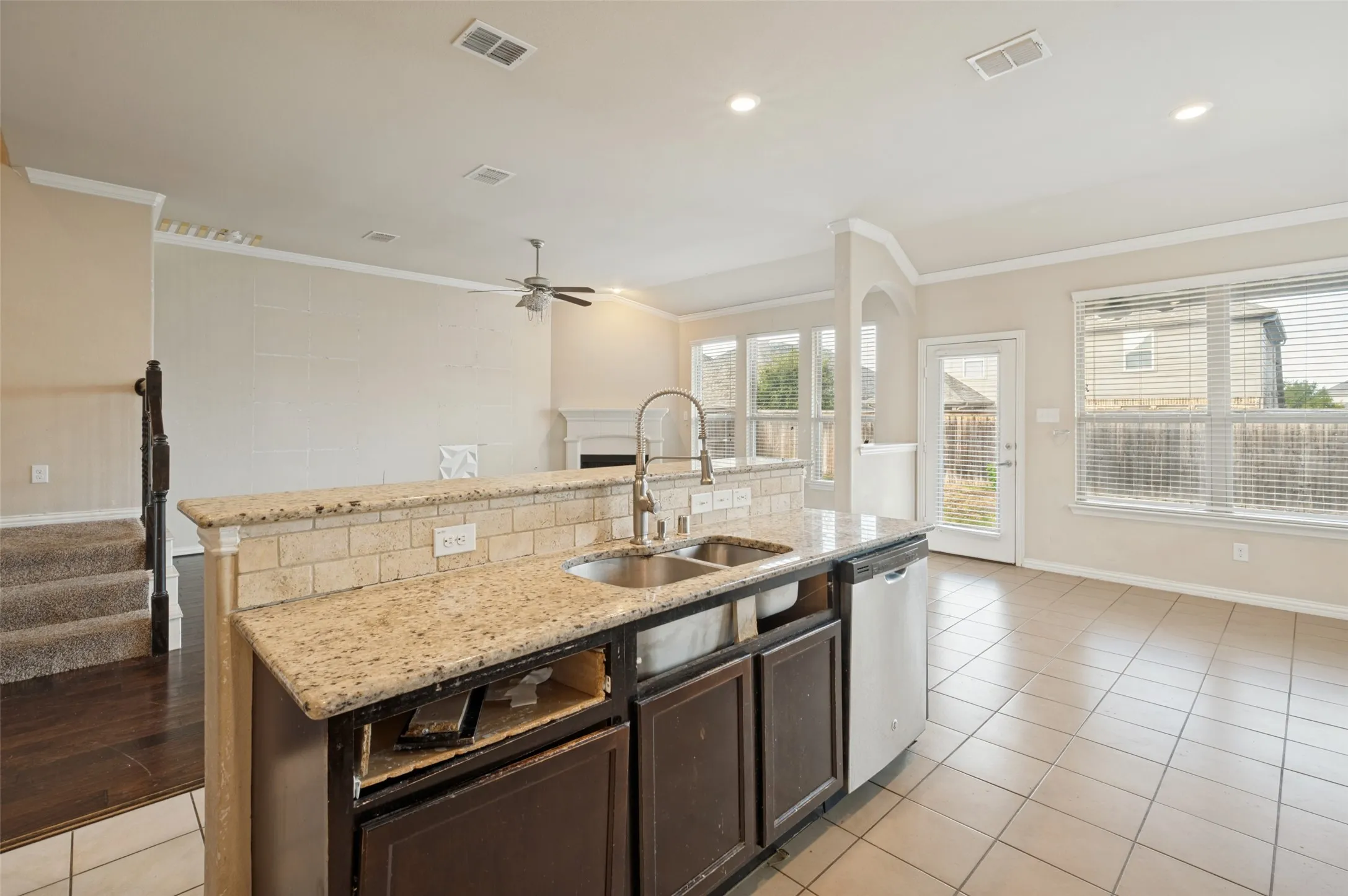 Kitchen island with granite countertop, stainless steel double sink, and integrated dishwasher
