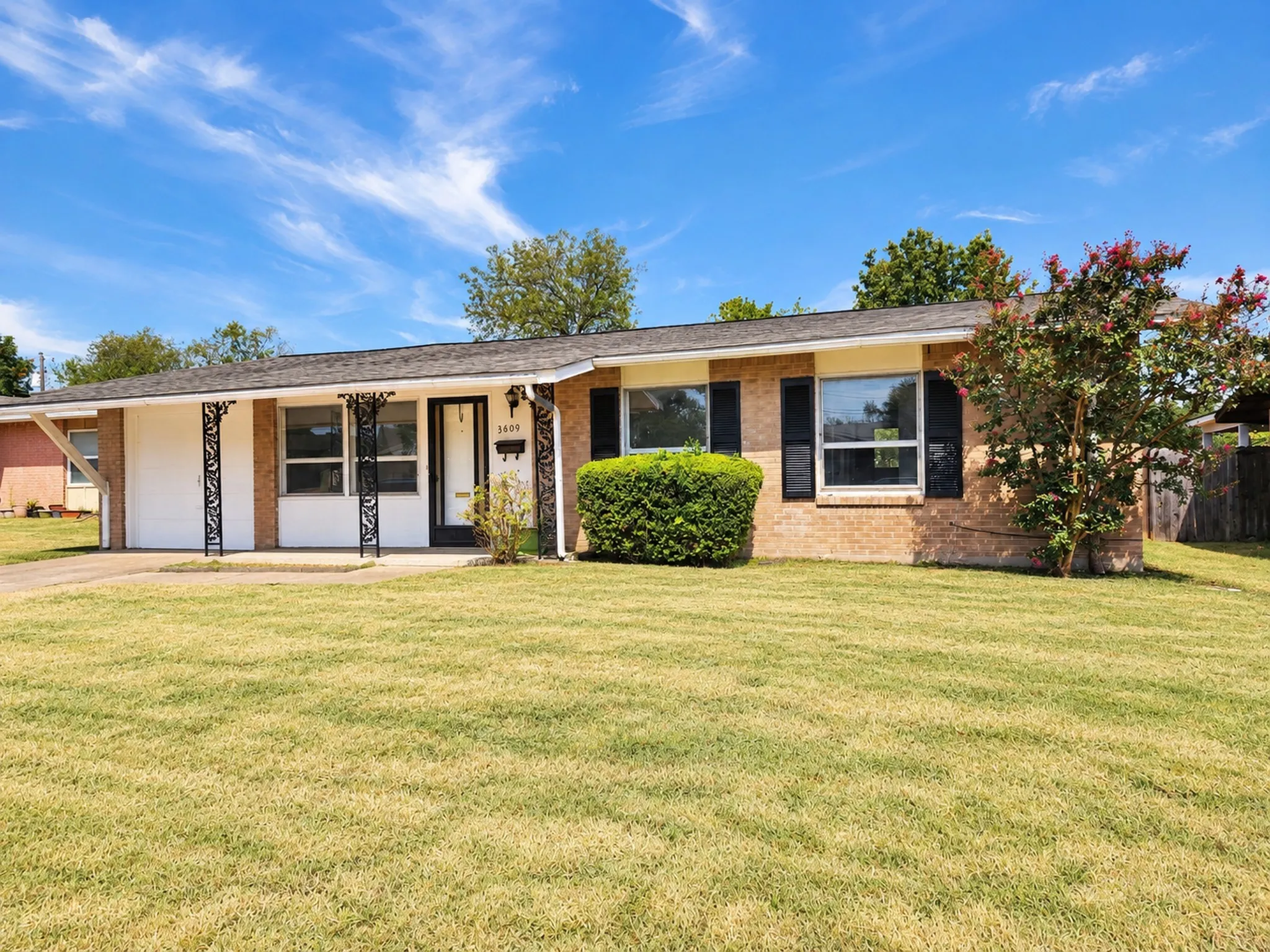 Single-story residence featuring a brick exterior and a paved driveway