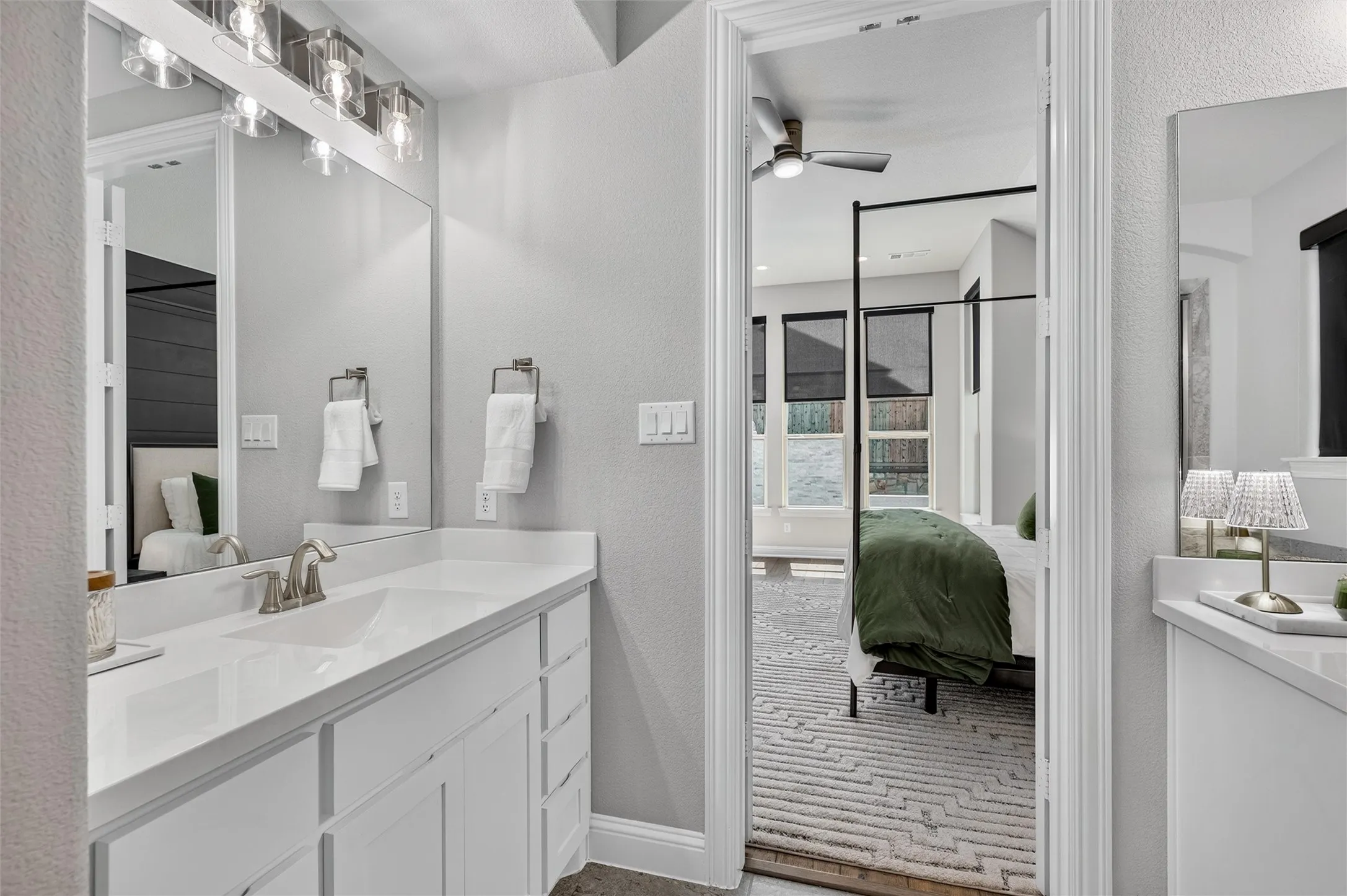 White vanity with a single undermount sink, brushed nickel faucet, and a large mirror