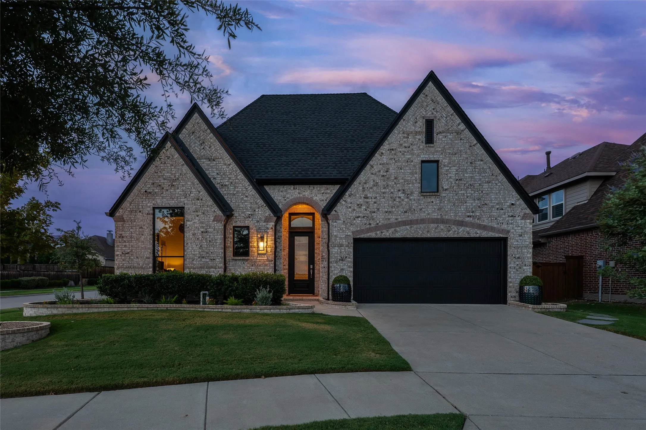 Brick exterior with dark roof, arched entryway, and dark-framed windows