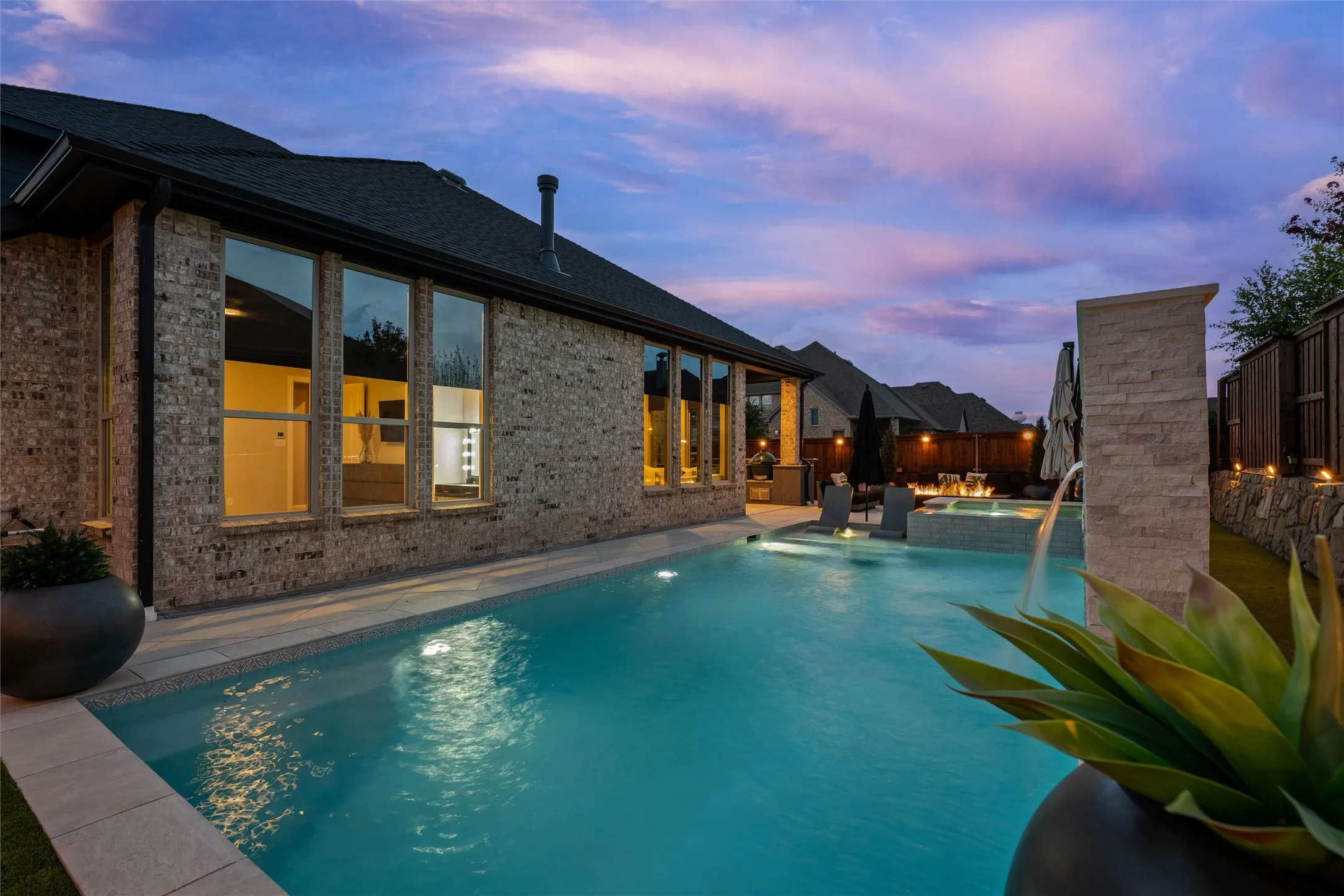Rectangular swimming pool with integrated spa and water feature