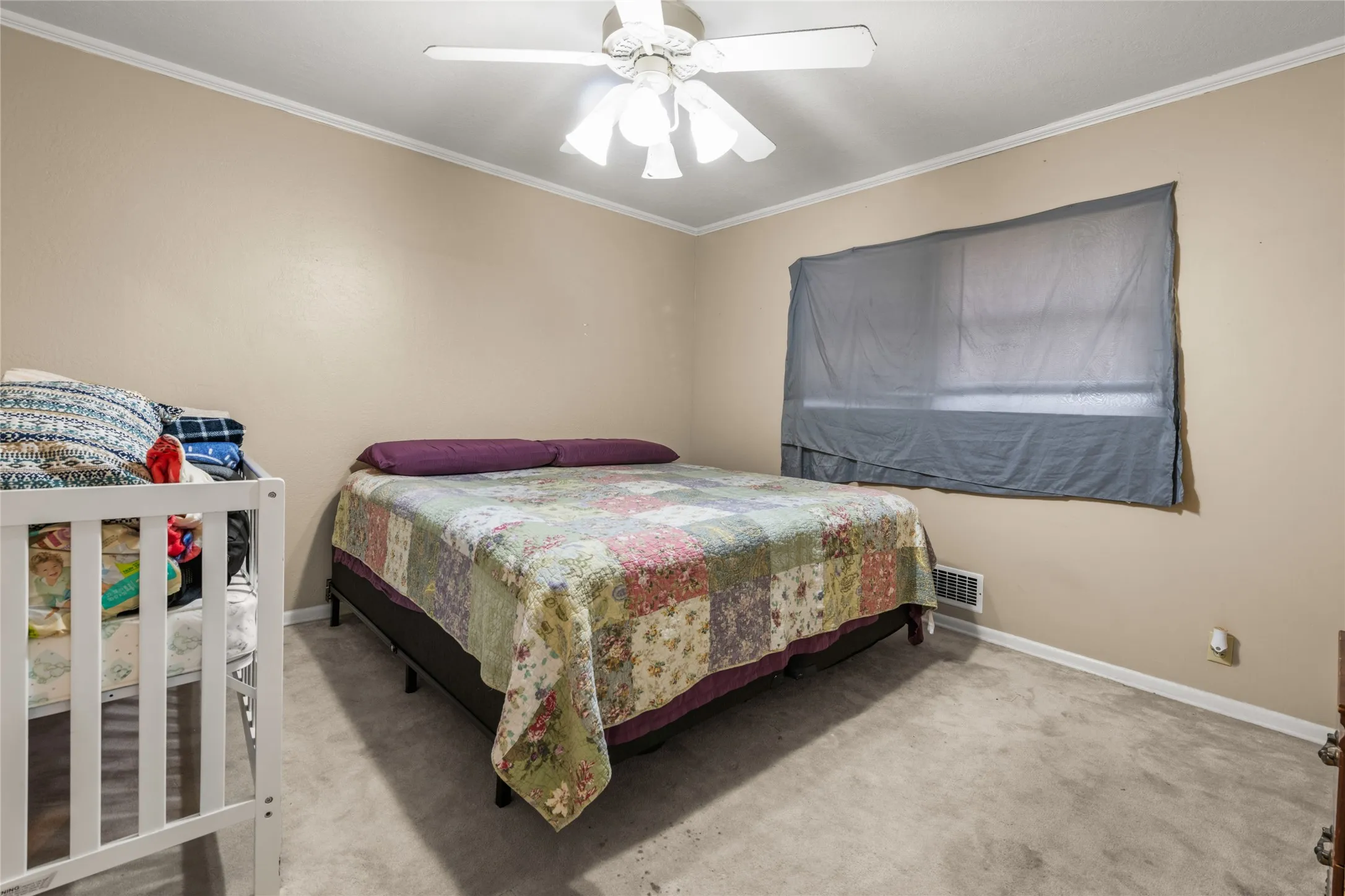 Ceiling fan with integrated lighting, neutral wall paint, white trim, and light-colored carpeting