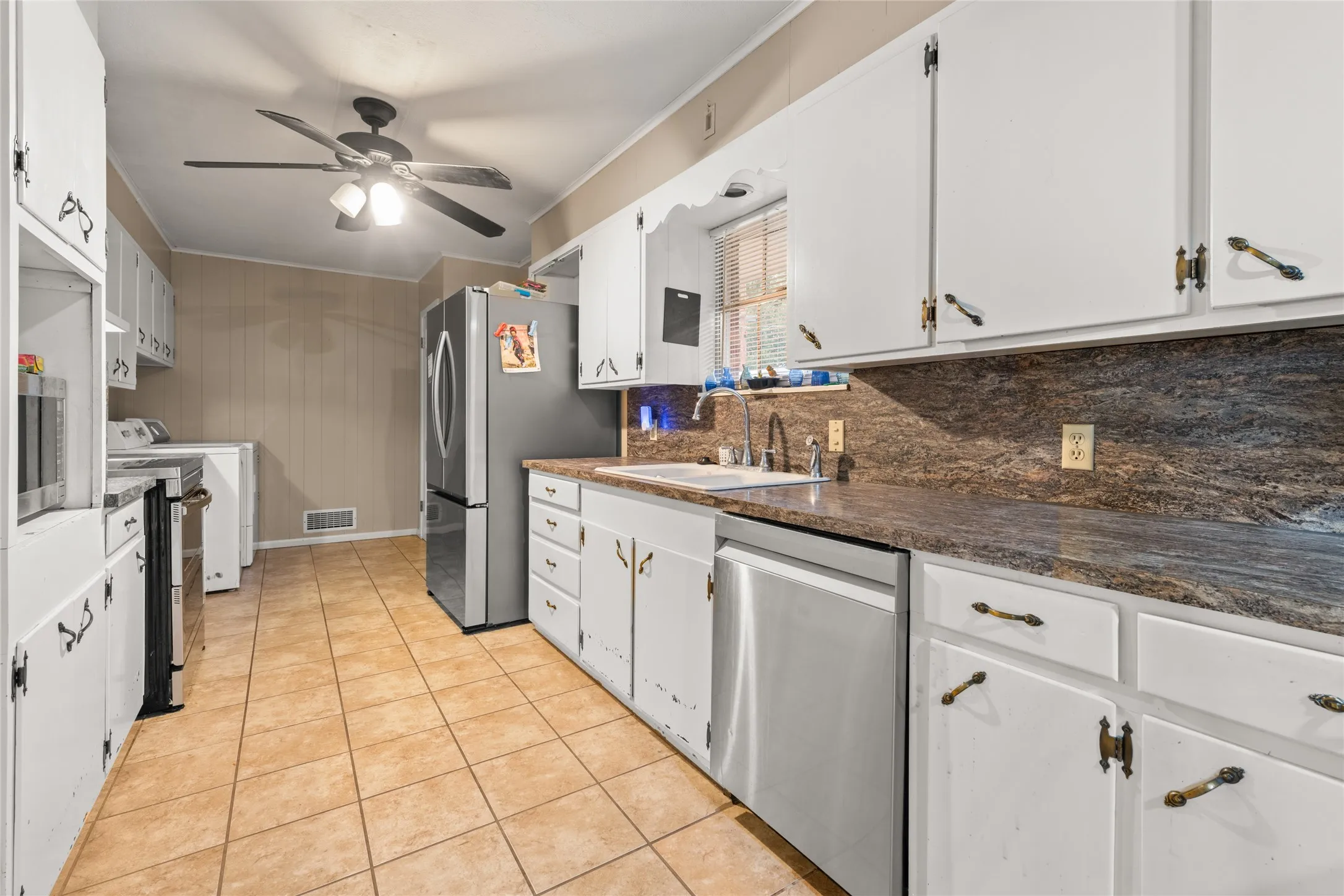 Kitchen featuring white cabinetry, a built-in stainless steel dishwasher, a stainless steel sink with a gooseneck faucet, and brown patterned countertops with matching​​‌​​​​‌​​‌‌​‌‌​​​‌‌​‌​‌​‌​​​‌​​ backsplash