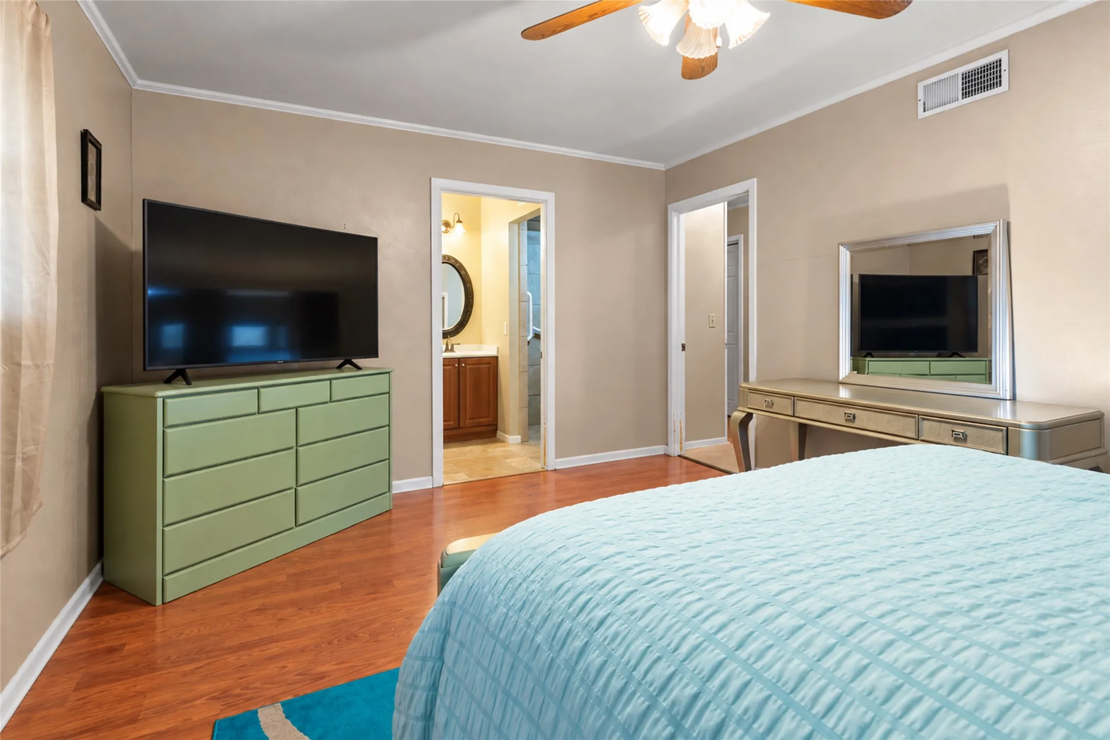 Wood-finish flooring throughout, with a ceiling fan featuring integrated lighting