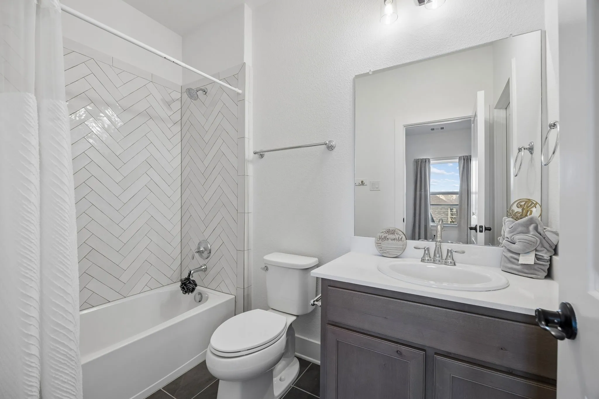 White subway tile in a herringbone pattern surrounds the tub and shower combination