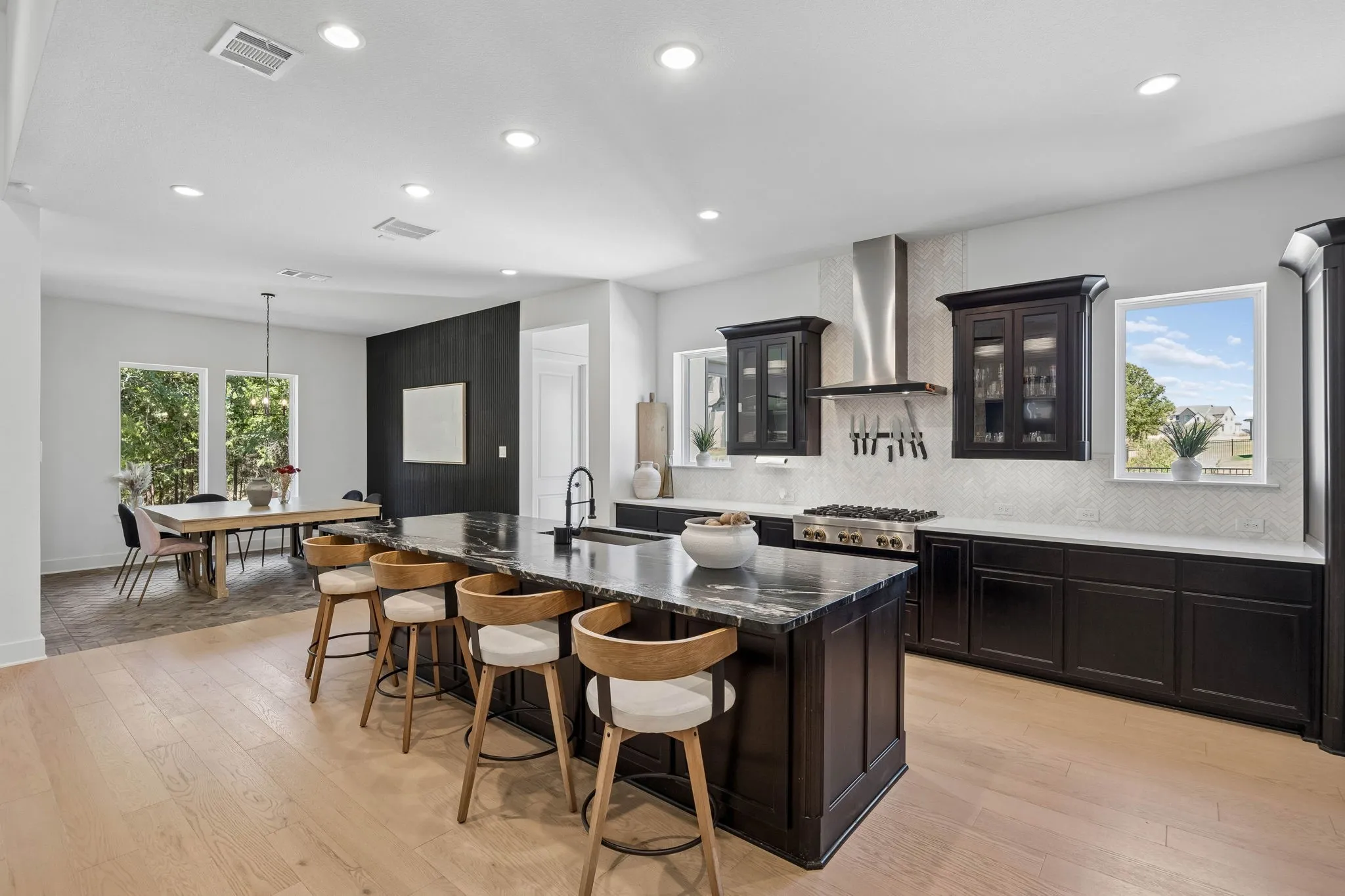 Hardwood-finish flooring, recessed lighting, and a kitchen island with seating