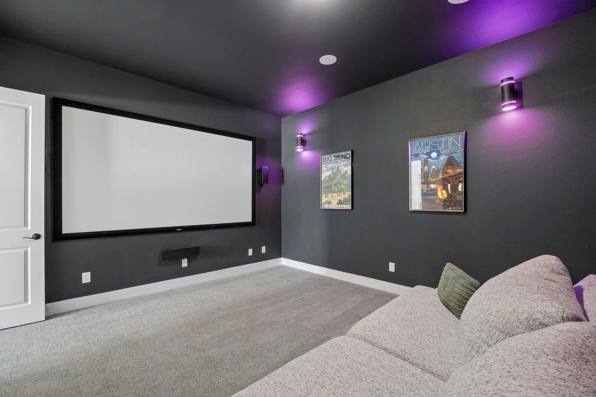 Media room featuring a large projection screen, wall-mounted speakers, recessed lighting, and carpeted flooring