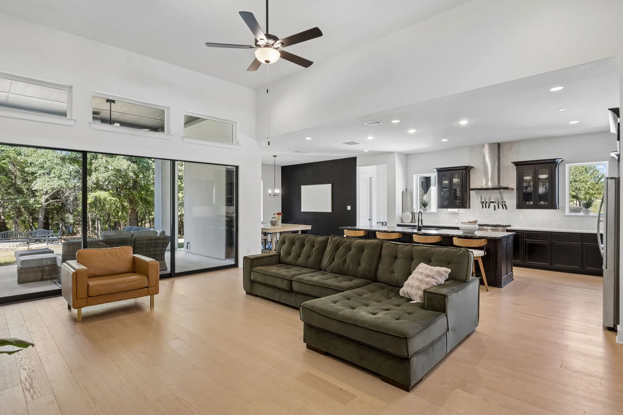 Open-concept living space featuring wood-finish flooring, a vaulted ceiling, and recessed lighting