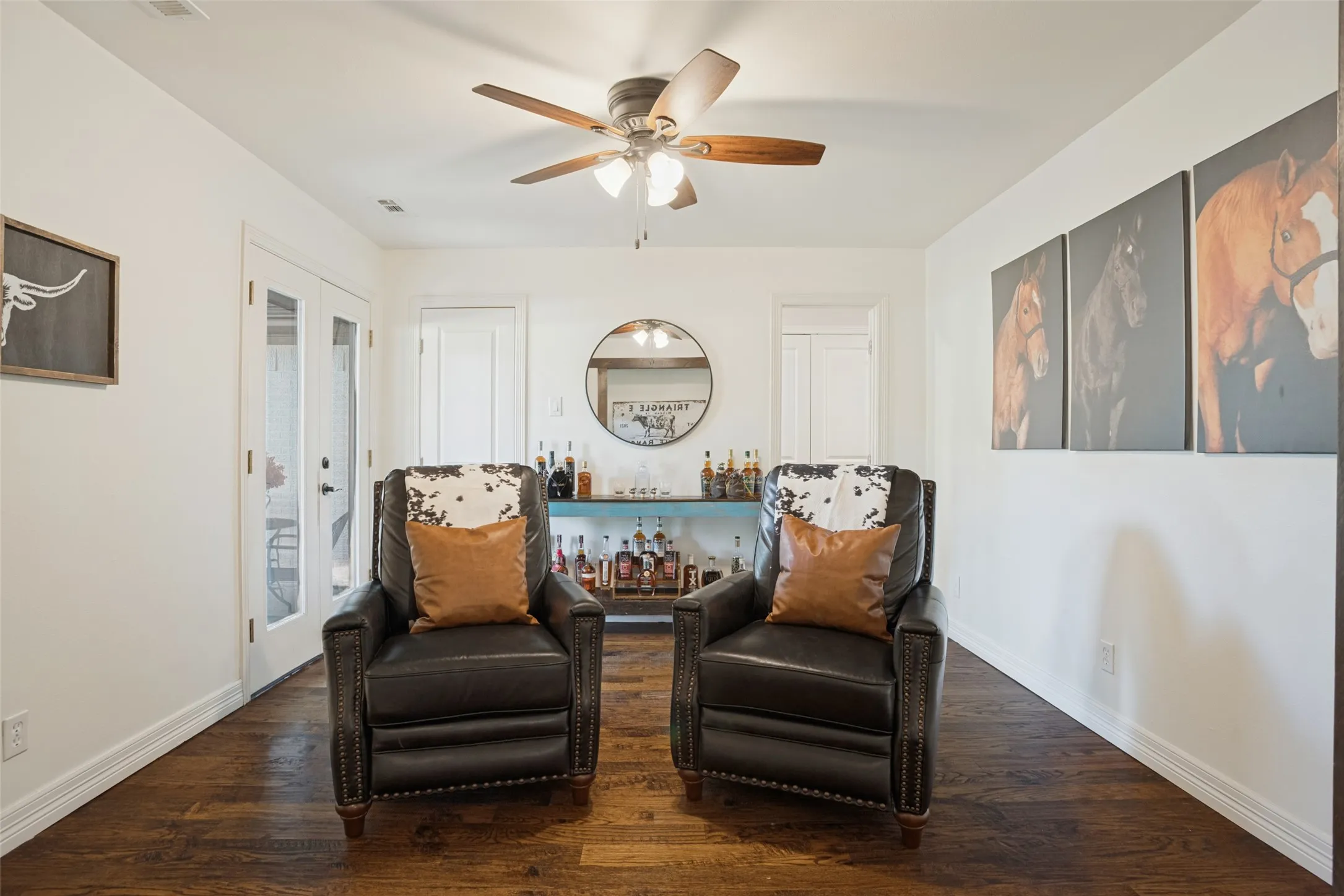 Front living/sitting room with doors to front courtyard, closet, and sliding barn doors to entry.