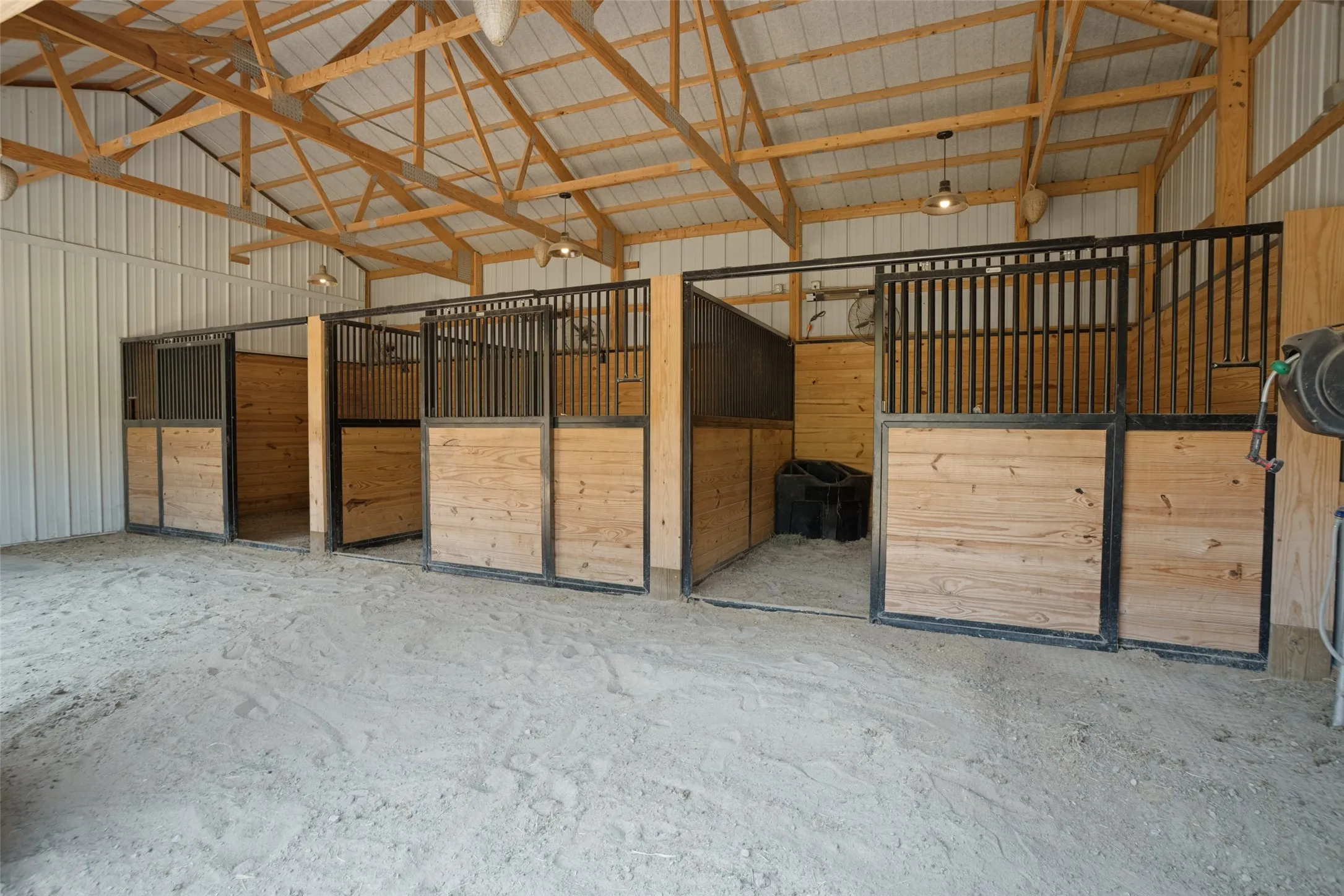 Three 12 x 12 stalls with fans, sand flooring, extra covered space in front of stalls can be used as a run-in shelter in rainy weather.