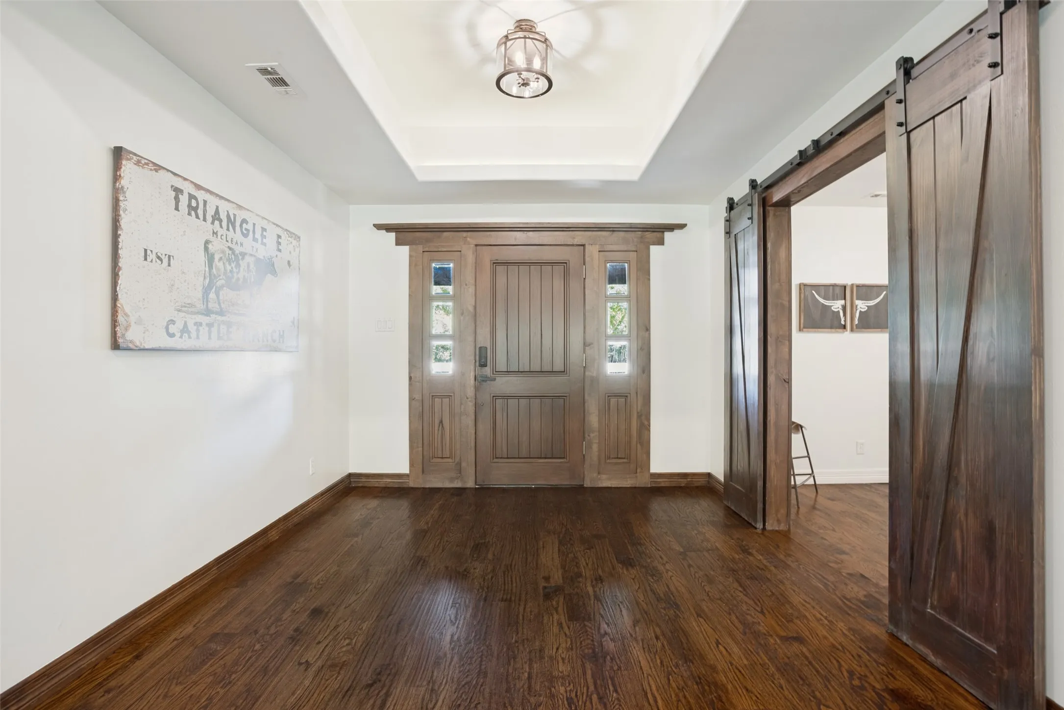 Oversized entry with raised ceiling, custom lighting, beautiful custom entry door.