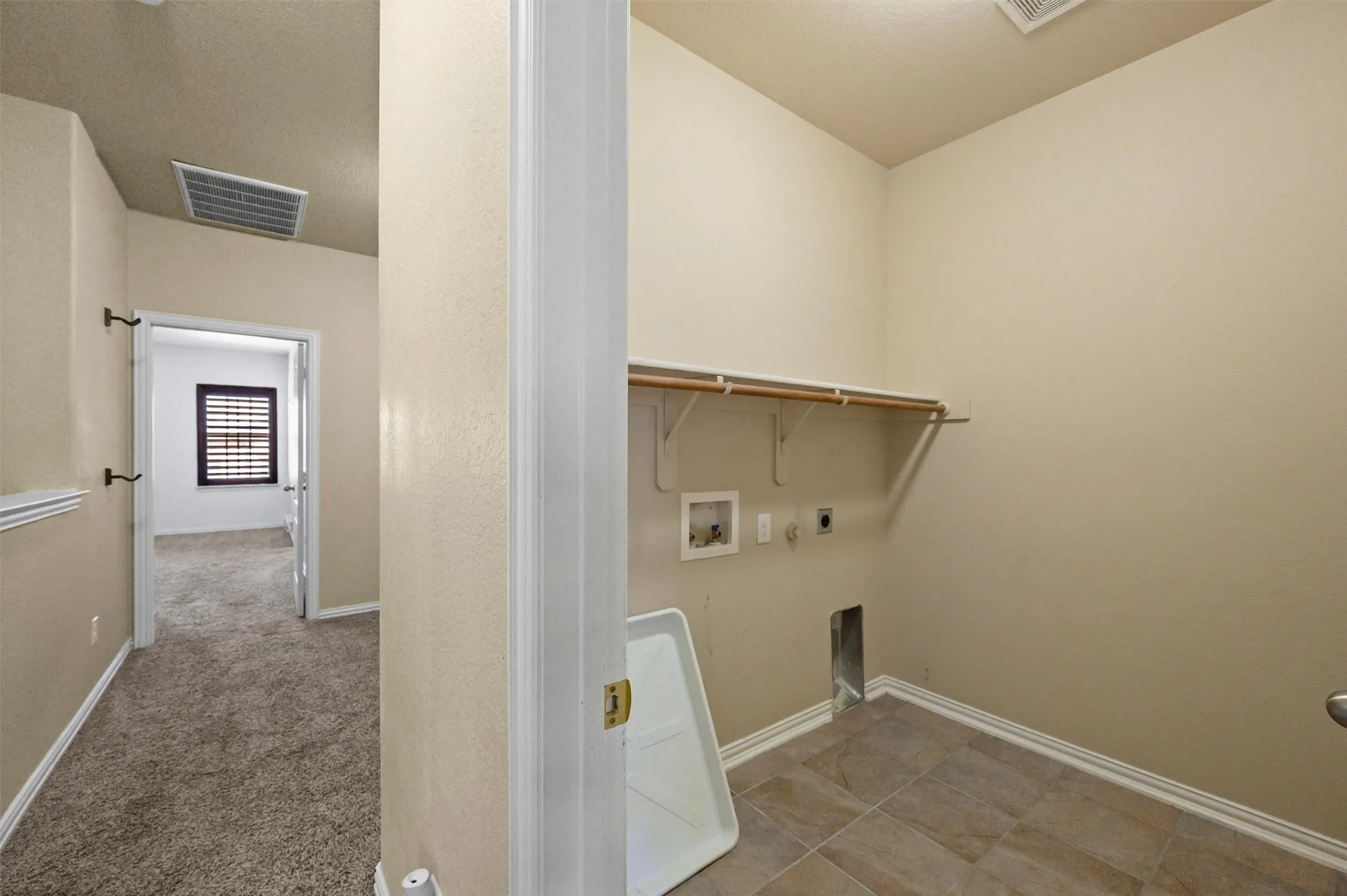 Laundry area featuring tile flooring, built-in shelving, and appliance hookups