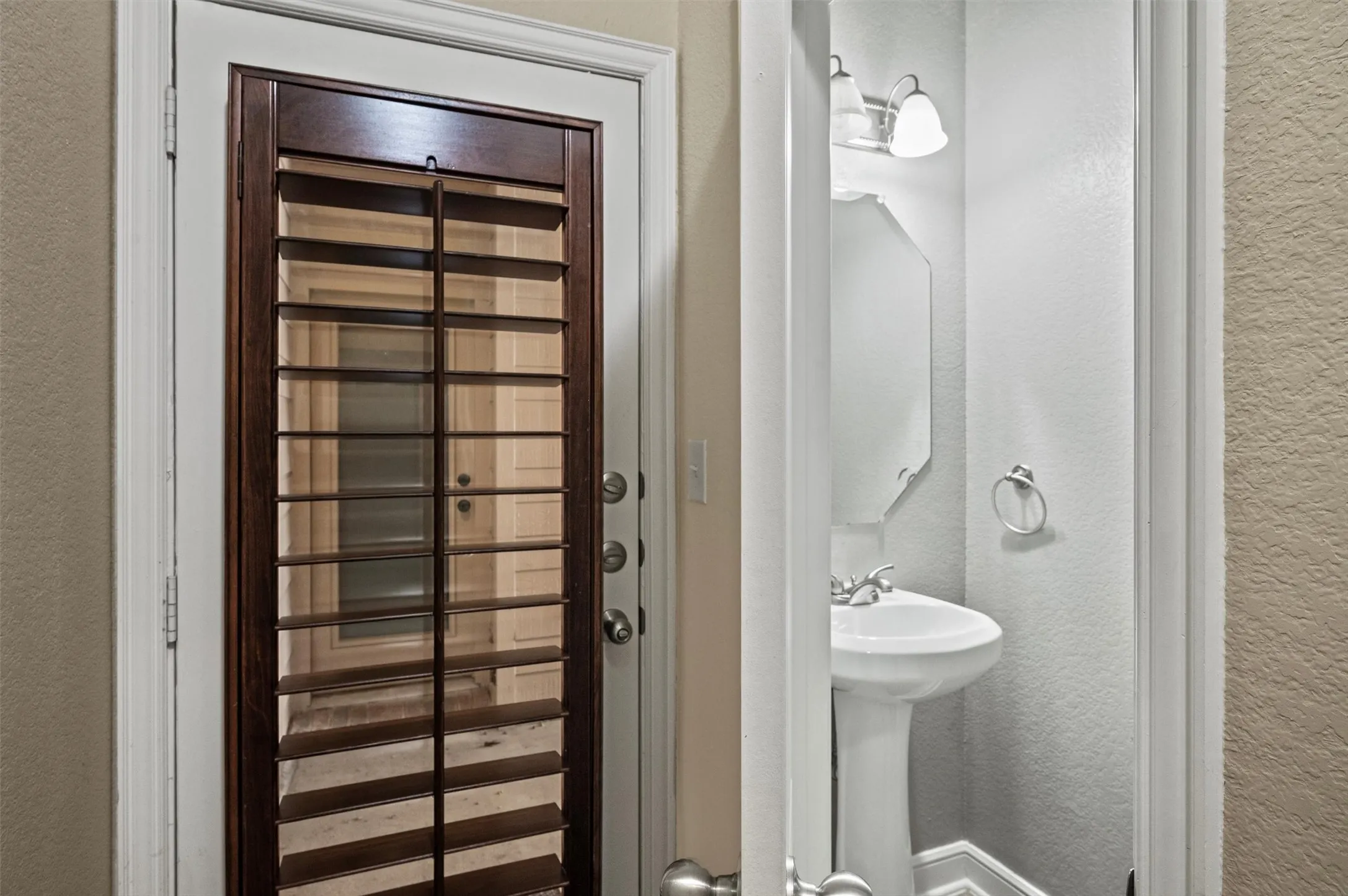 White exterior door with dark wood-finish interior shutters