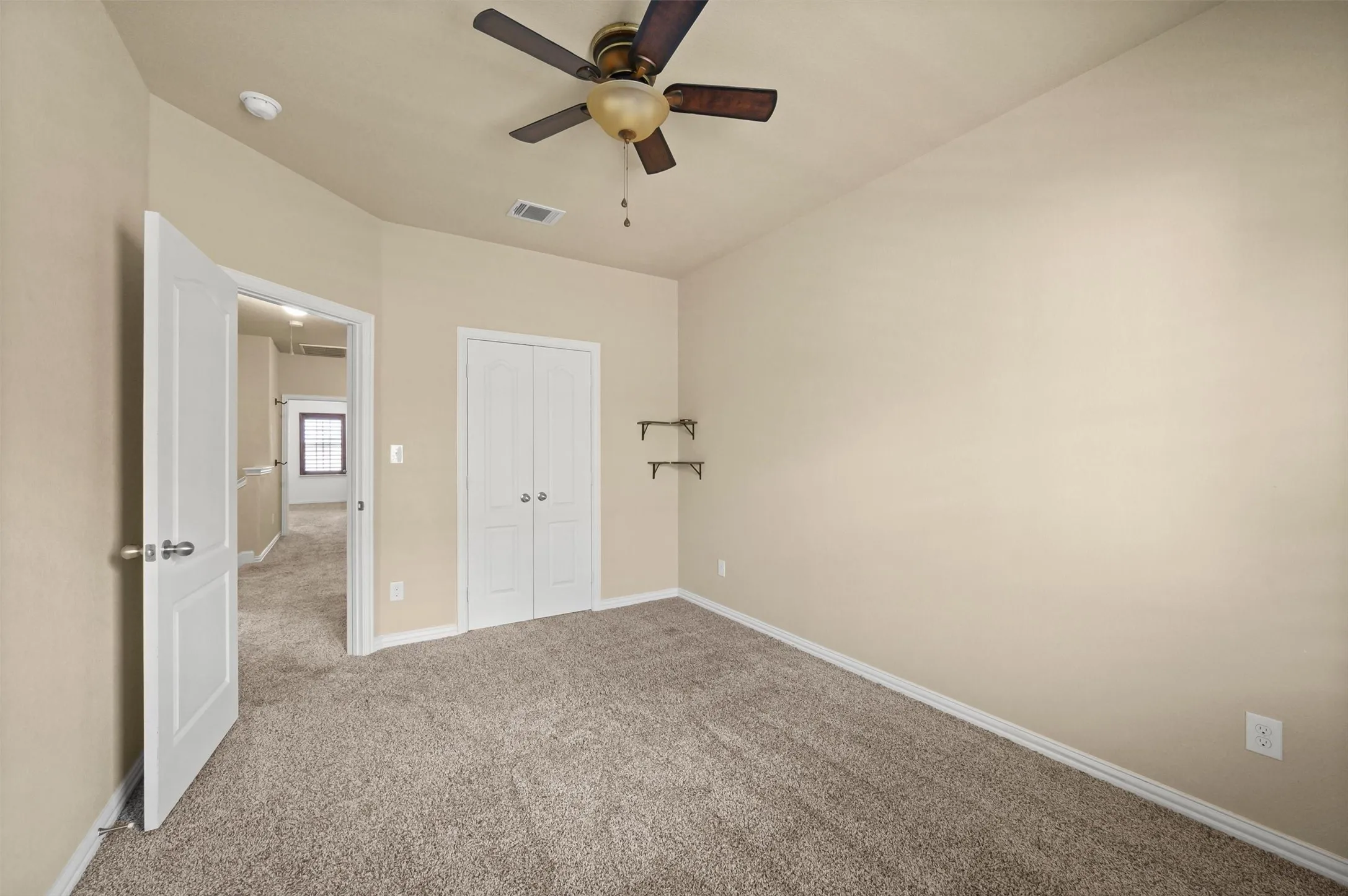 Carpeted flooring, bi-fold closet doors, ceiling fan, and painted walls