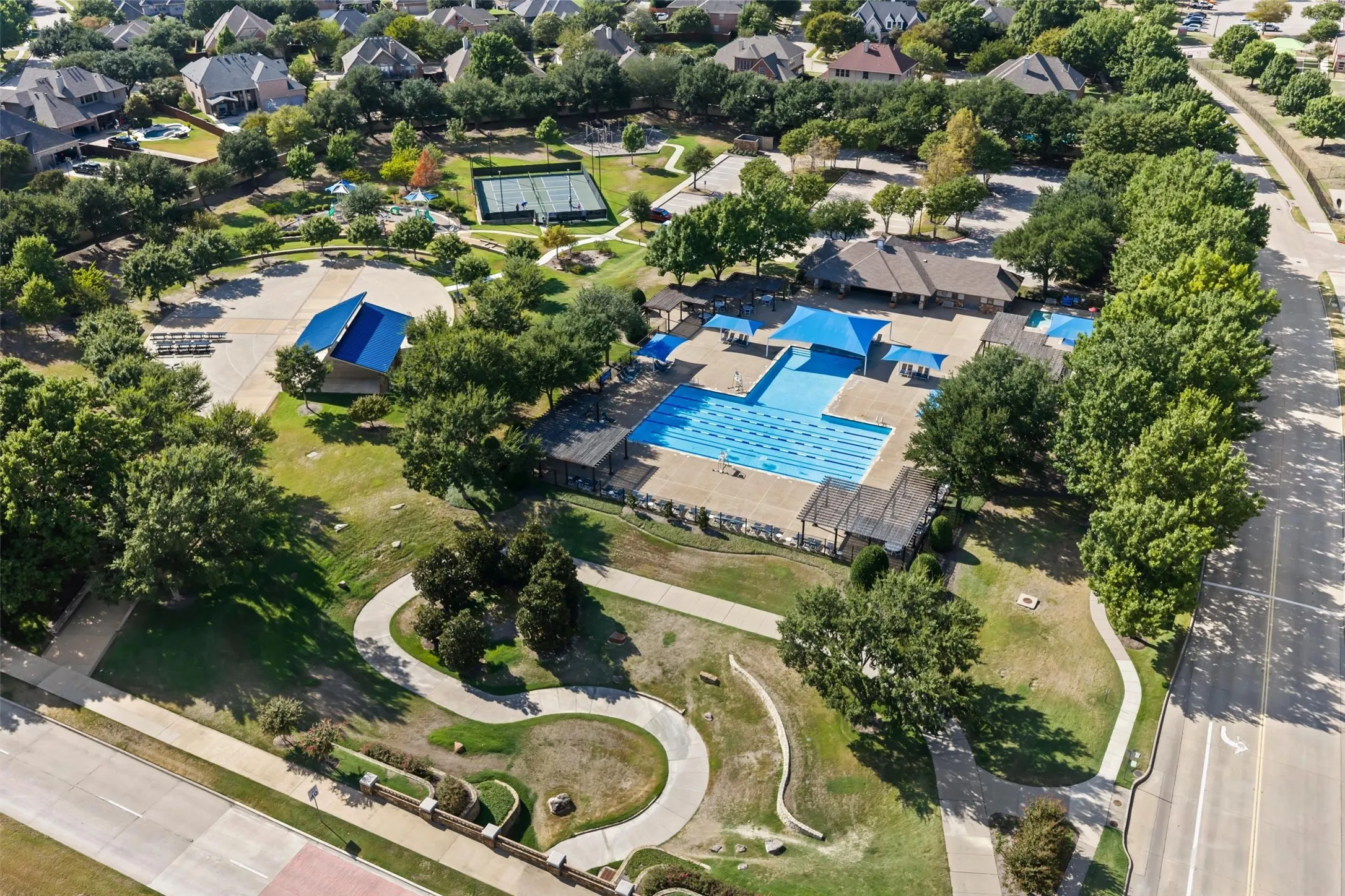 Community amenities featuring multiple swimming pools, tennis courts, a clubhouse, and paved walking paths