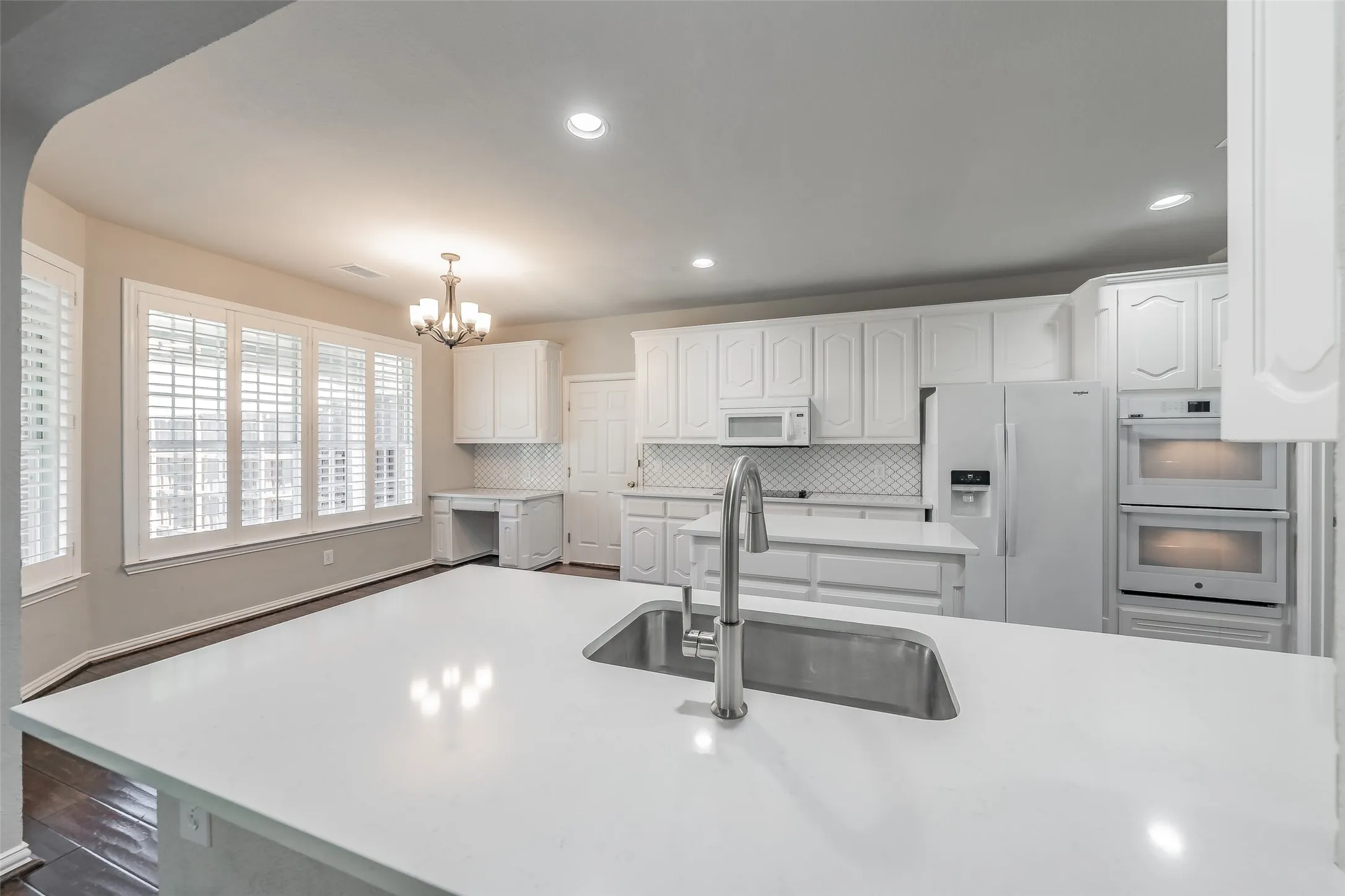 Expansive kitchen island with an undermount sink and gooseneck faucet