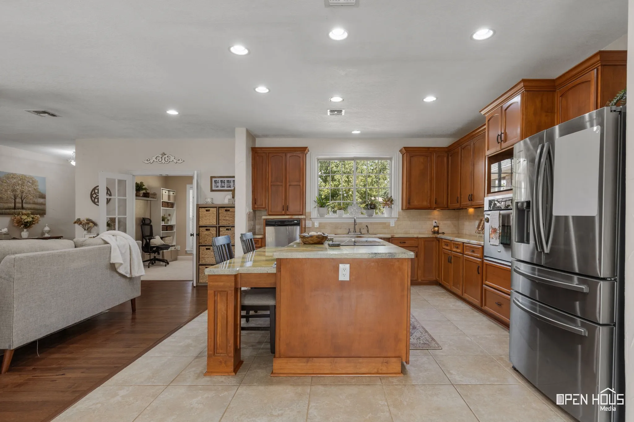 Recessed lighting, wood-finish cabinetry, stainless steel appliances, stone countertops, and tile flooring