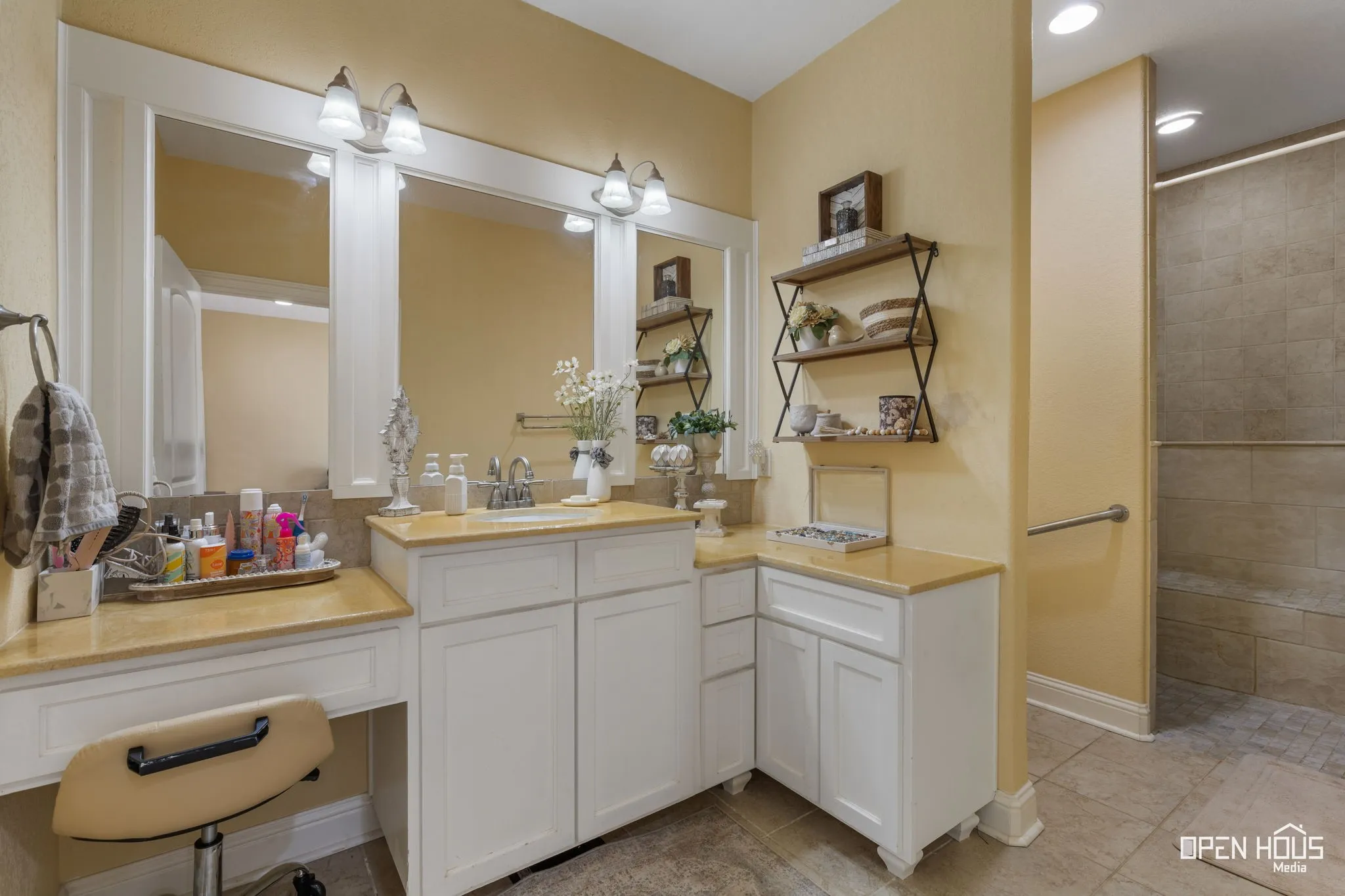 Double vanity with integrated sink, light-colored countertops, and white cabinetry