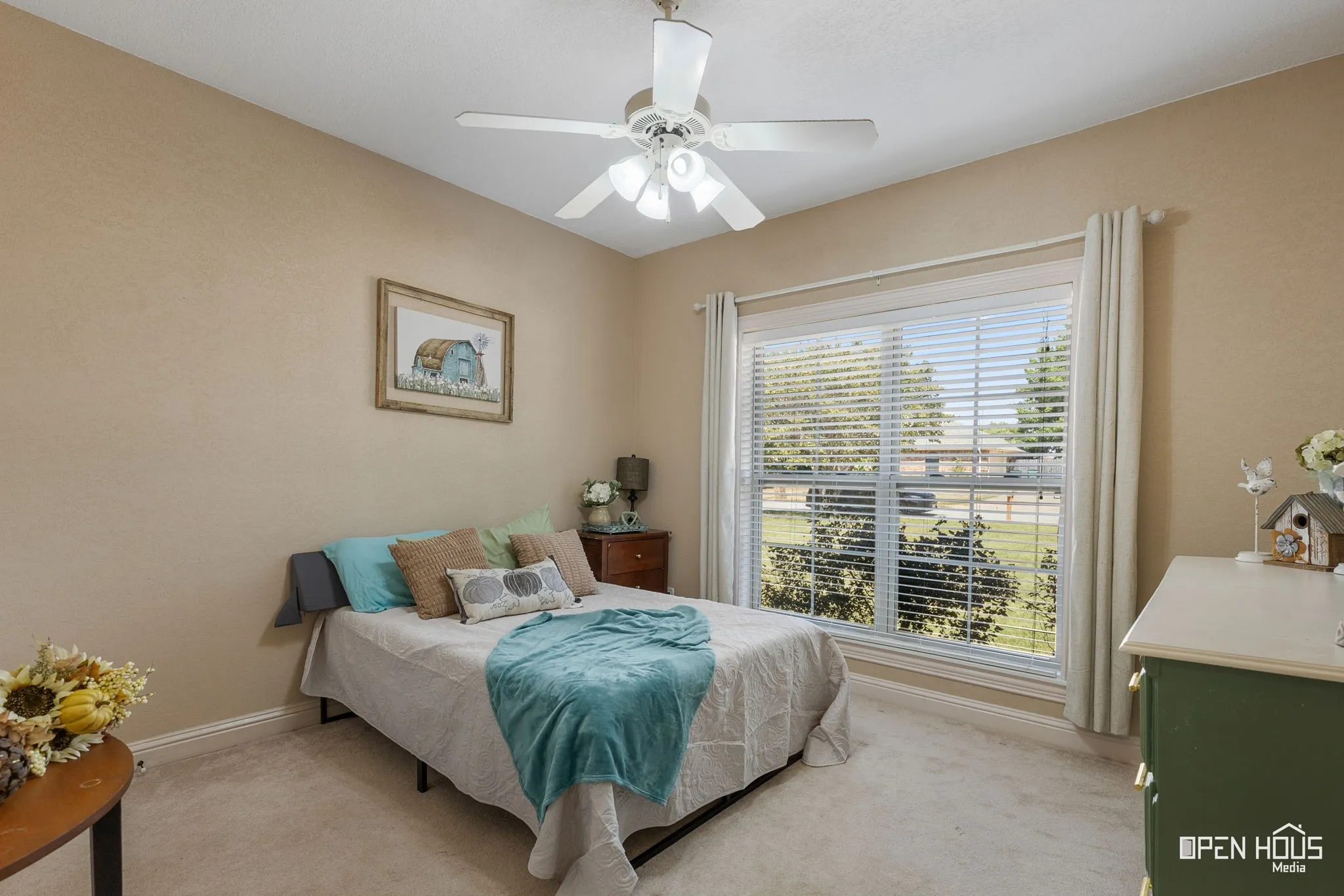 Neutral wall color, carpet flooring, a ceiling fan with integrated lighting, and a large window with blinds