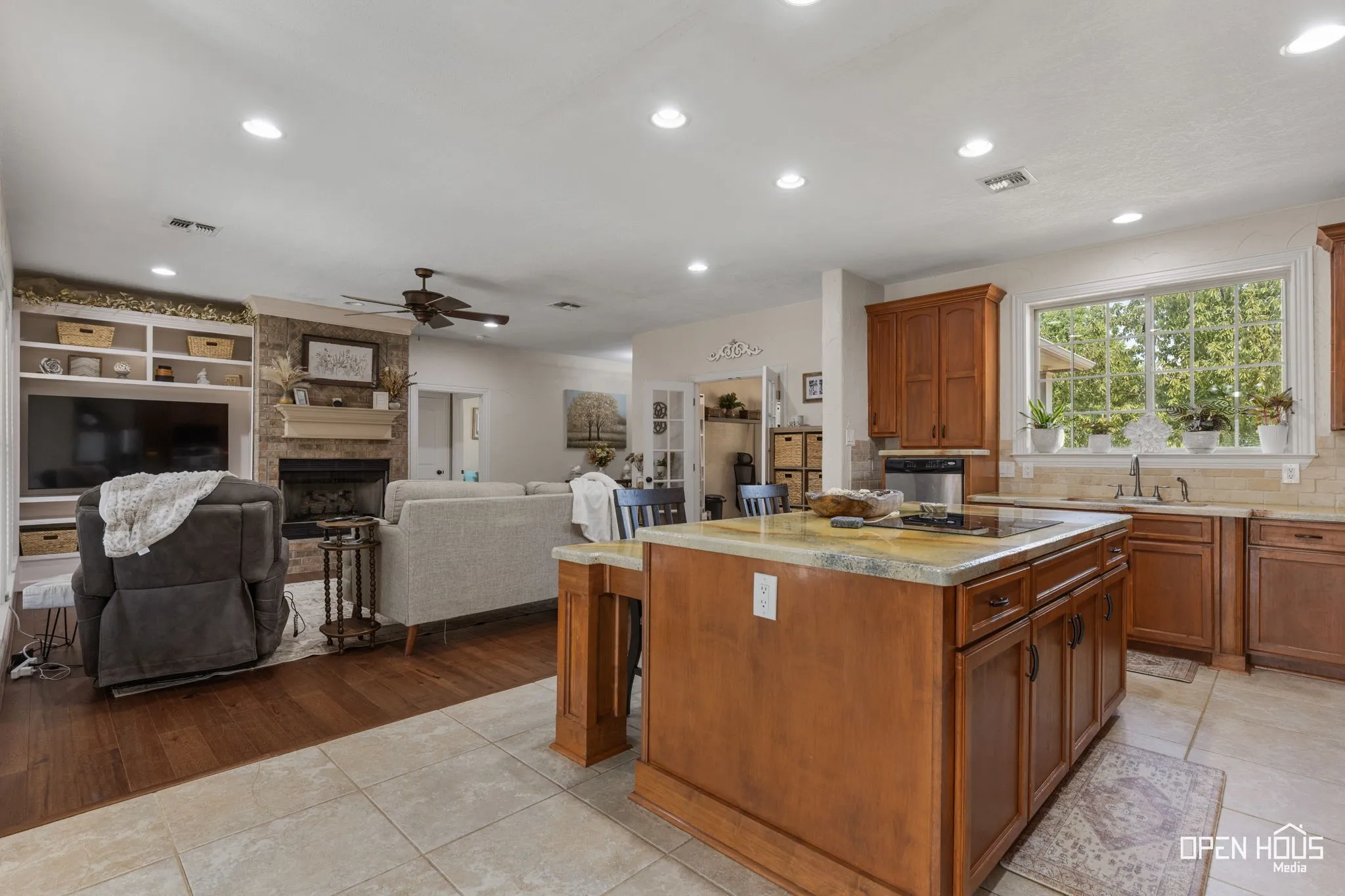 Kitchen island with countertop, wood-finish cabinetry, and built-in stovetop