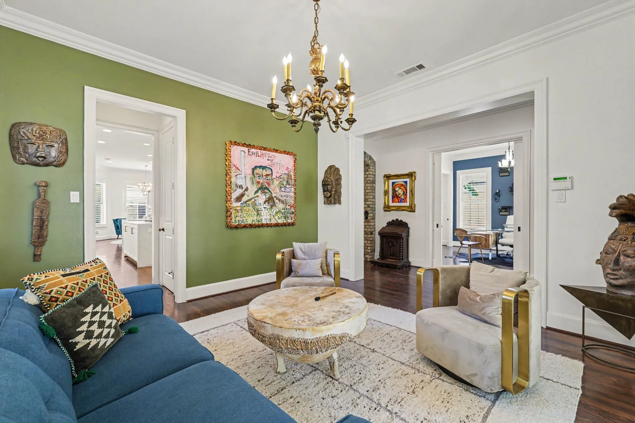 Hardwood flooring, crown molding, and a decorative chandelier illuminate this space