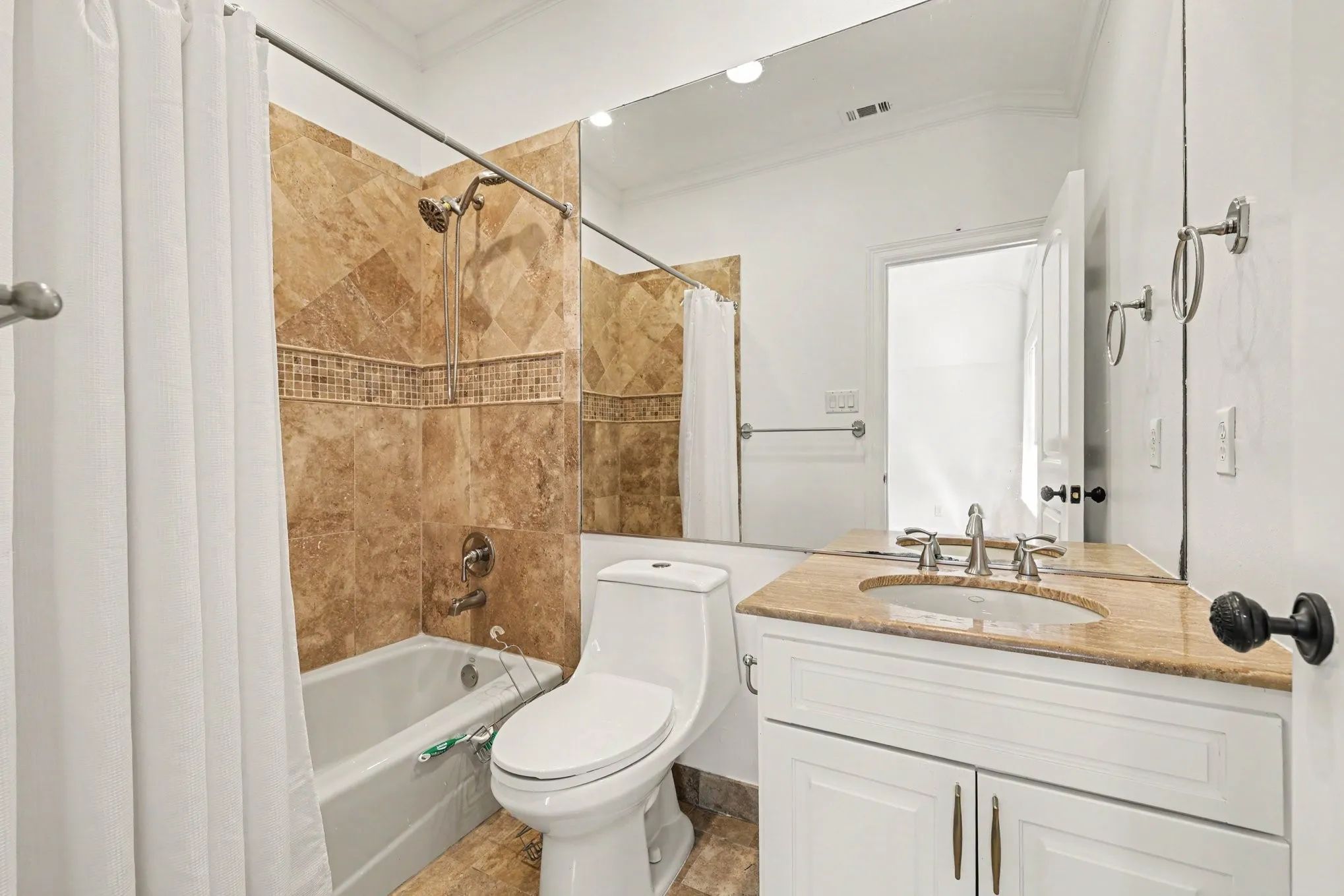 White vanity with a stone countertop, an undermount sink, and a large wall-mounted mirror