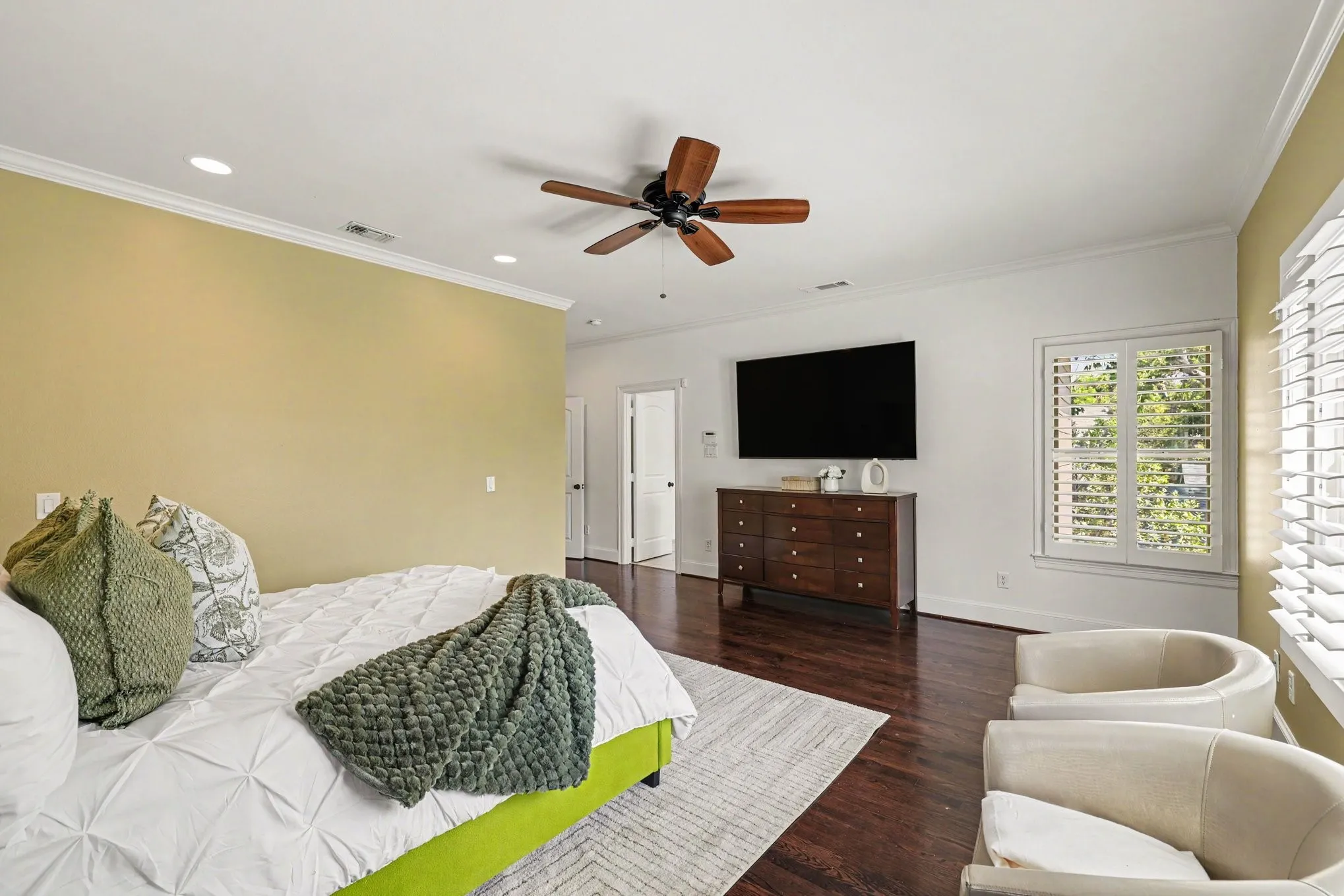 Hardwood flooring, recessed lighting, crown molding, ceiling fan, and plantation shutters