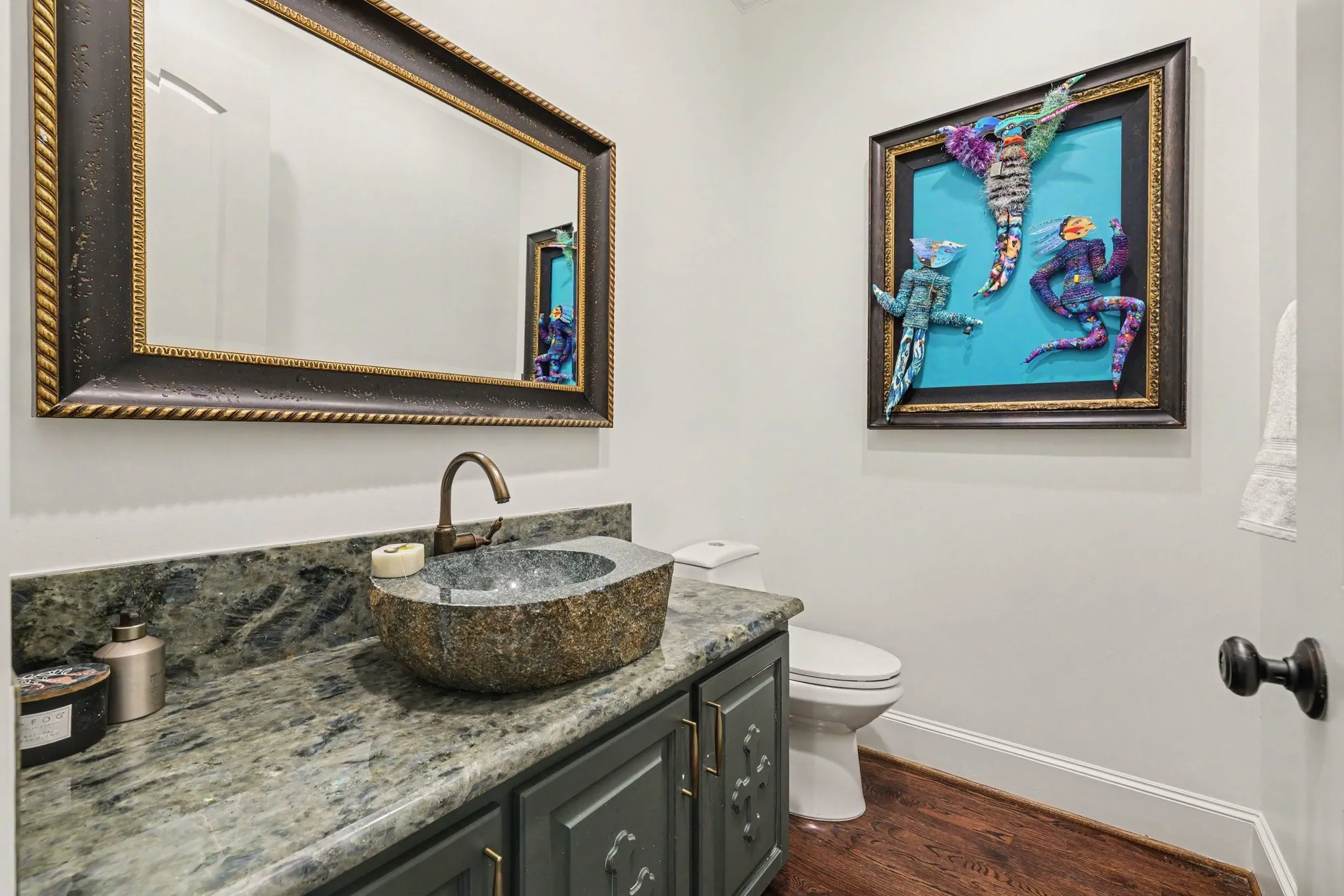 Stone vessel sink with a bronze-finish faucet, set atop a patterned stone countertop