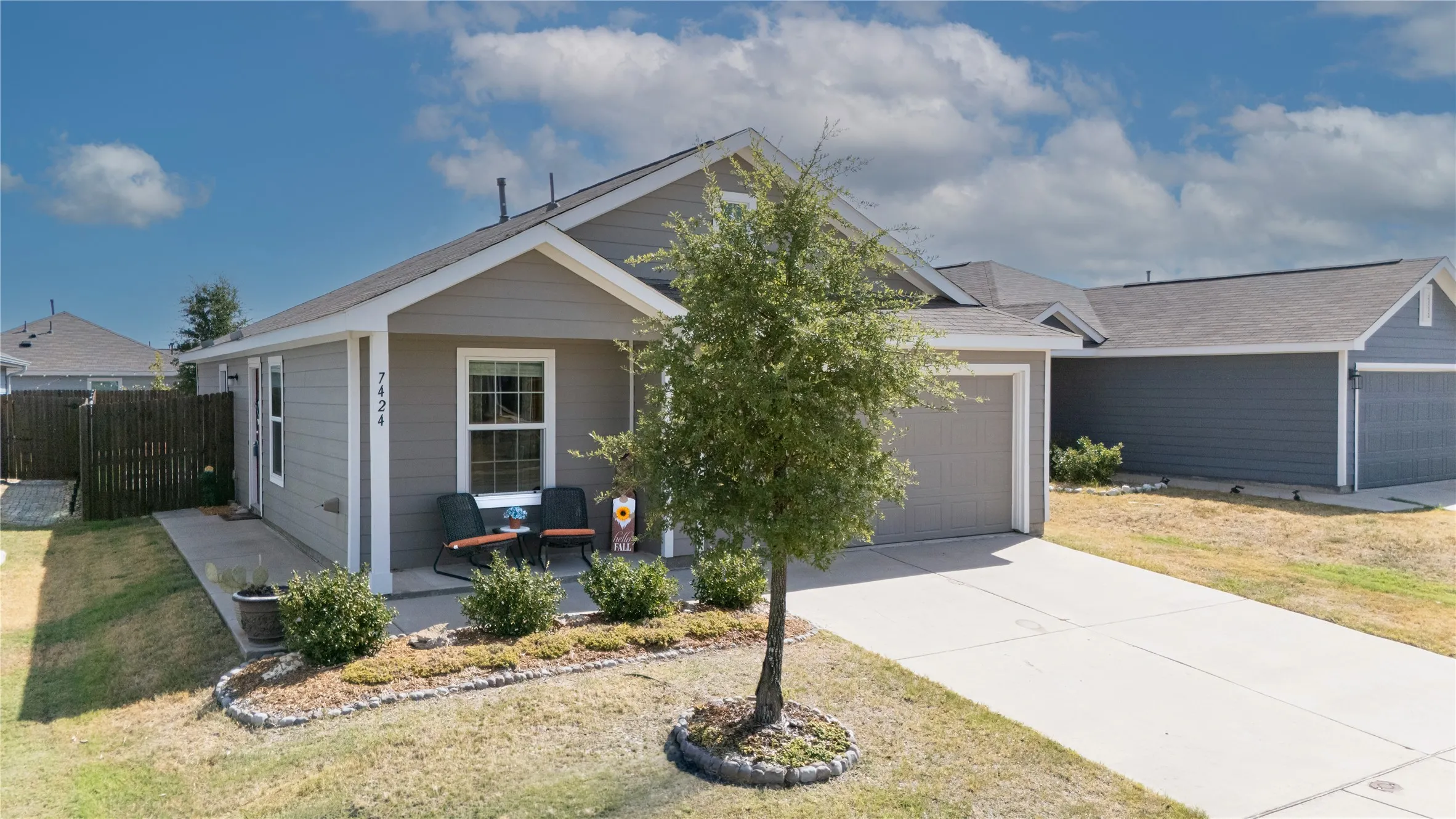 WELCOME HOME Single-story property with a light gray facade, a covered front porch, and a concrete driveway