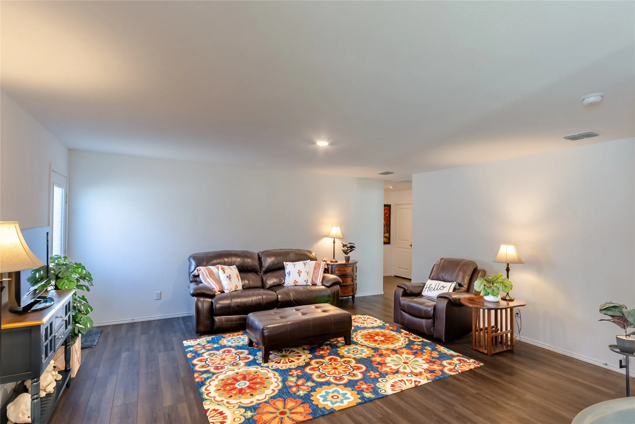 Wood-finish flooring throughout, white painted walls, and recessed ceiling lighting